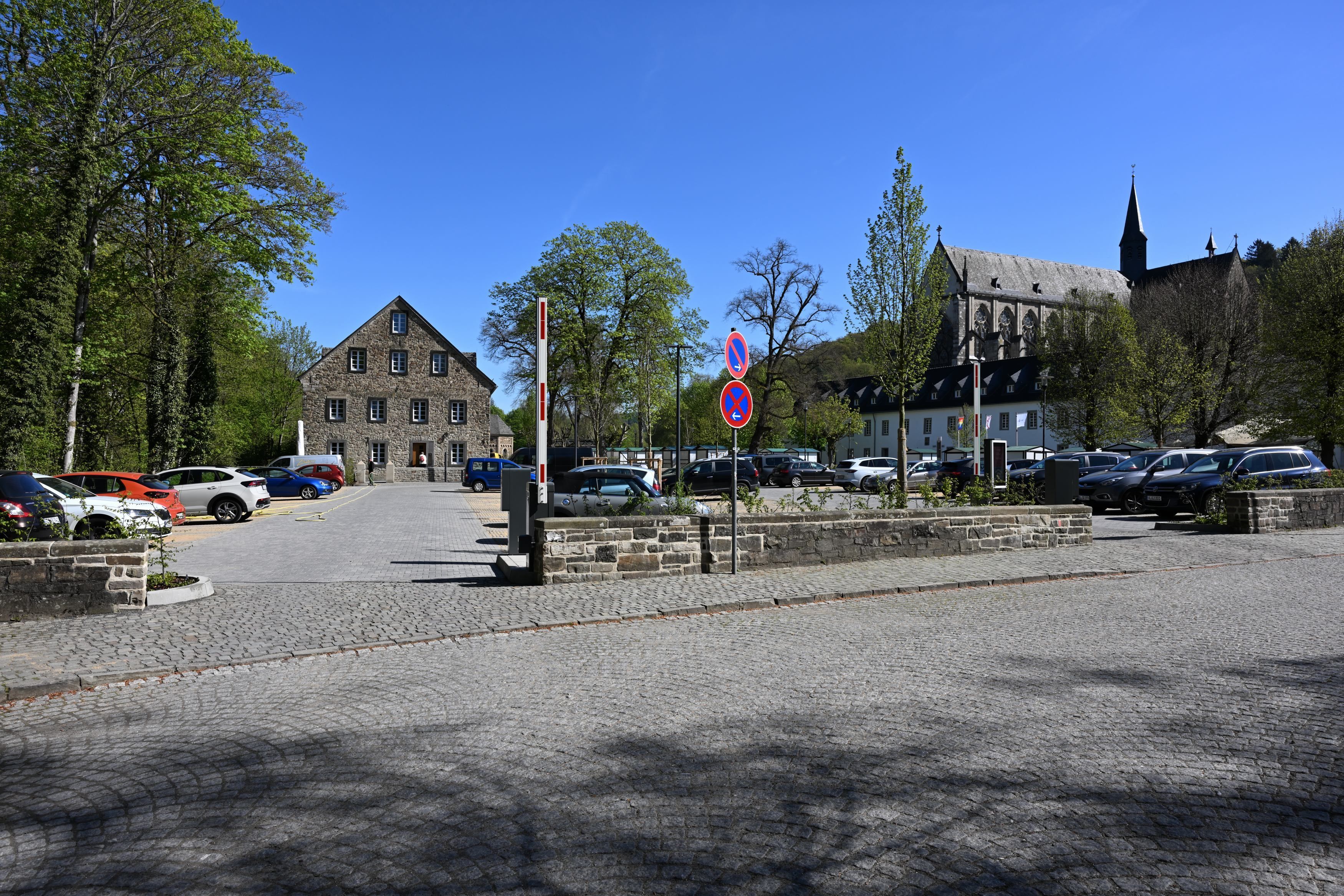Ein Parkplatz mit geöffneter Schranke vor dem Altenberger Dom.