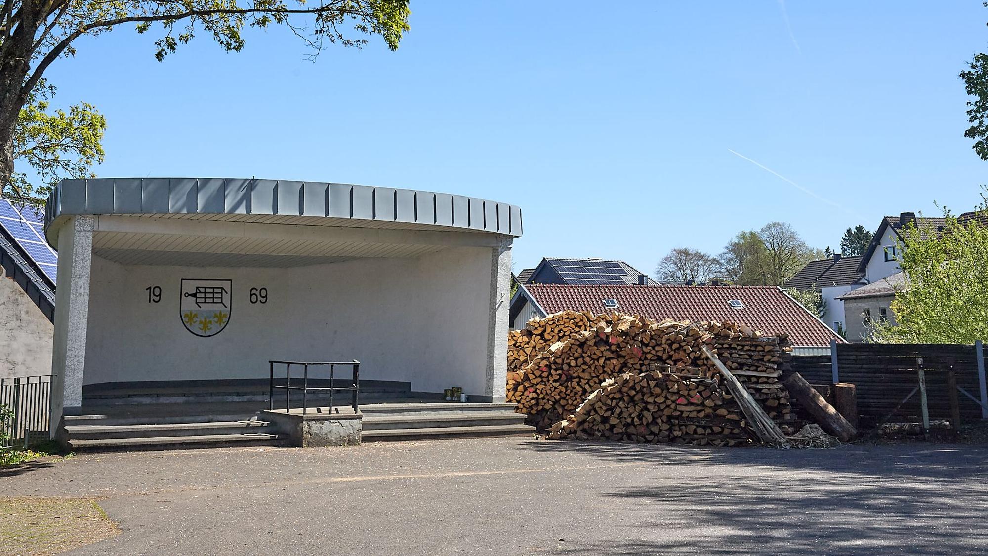 Neben der überdachten Bühne auf dem Eiffelplatz lagert eine größere Menge Holz.