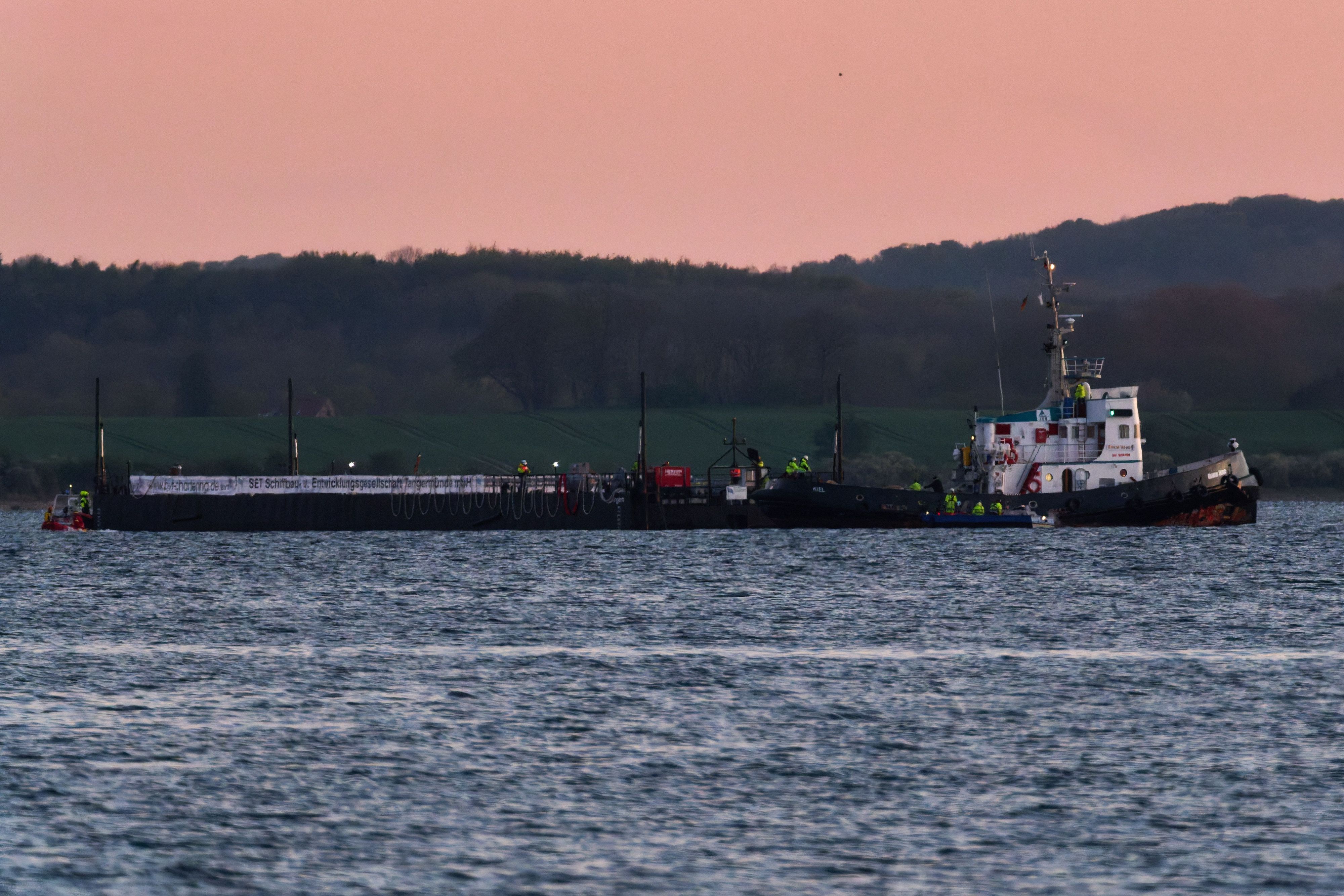 Das Schleppschiff Robin Hood (r) schleppt die Barge am Dienstagabend in die Ostsee Richtung Fehmarn.