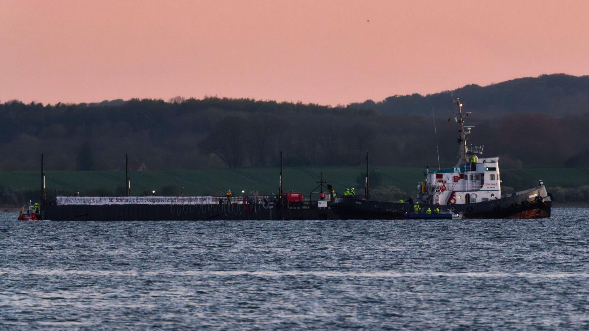 Das Schleppschiff Robin Hood (r) schleppt die Barge am Dienstagabend in die Ostsee Richtung Fehmarn.
