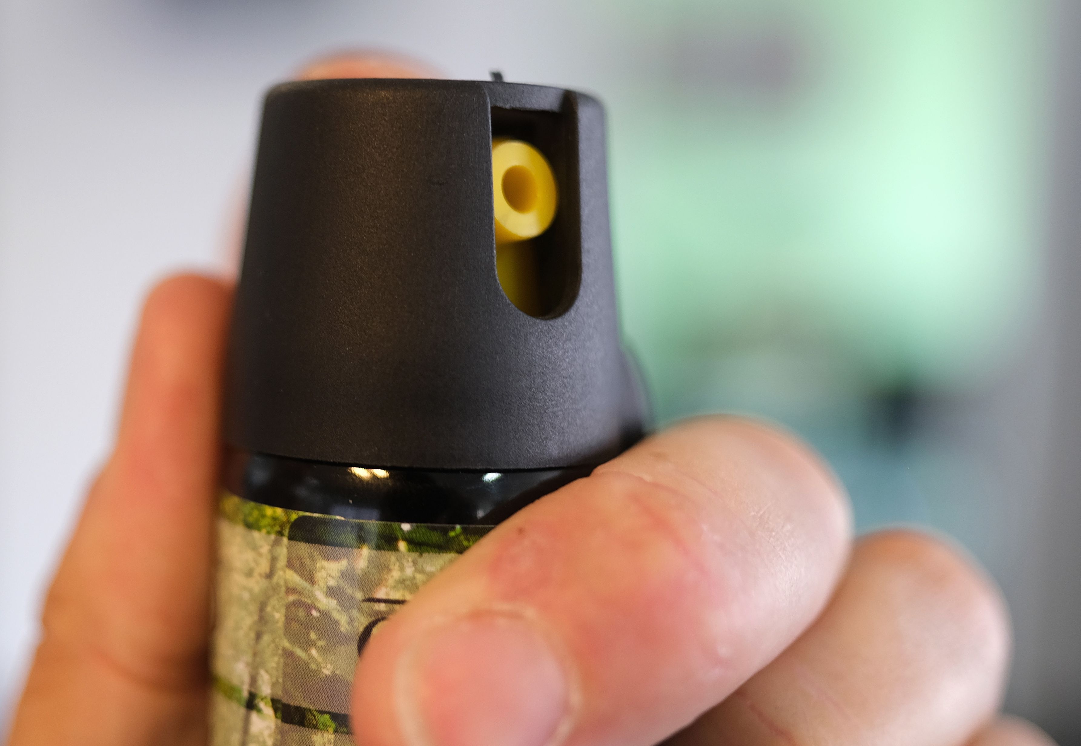 Eine Hand hält eine Kartusche mit Pfefferspray.