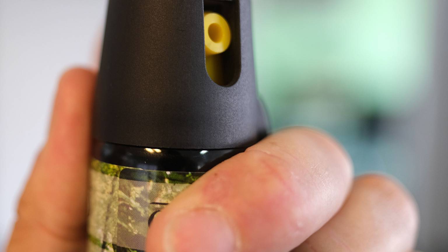 Eine Hand hält eine Kartusche mit Pfefferspray.