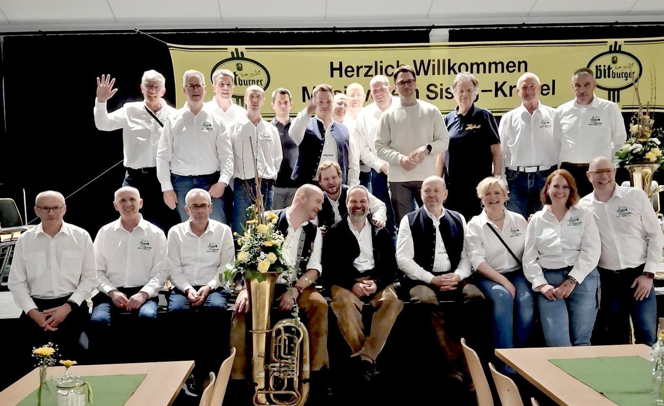 Die Musiker stehen oder sitzen auf der Bühne.