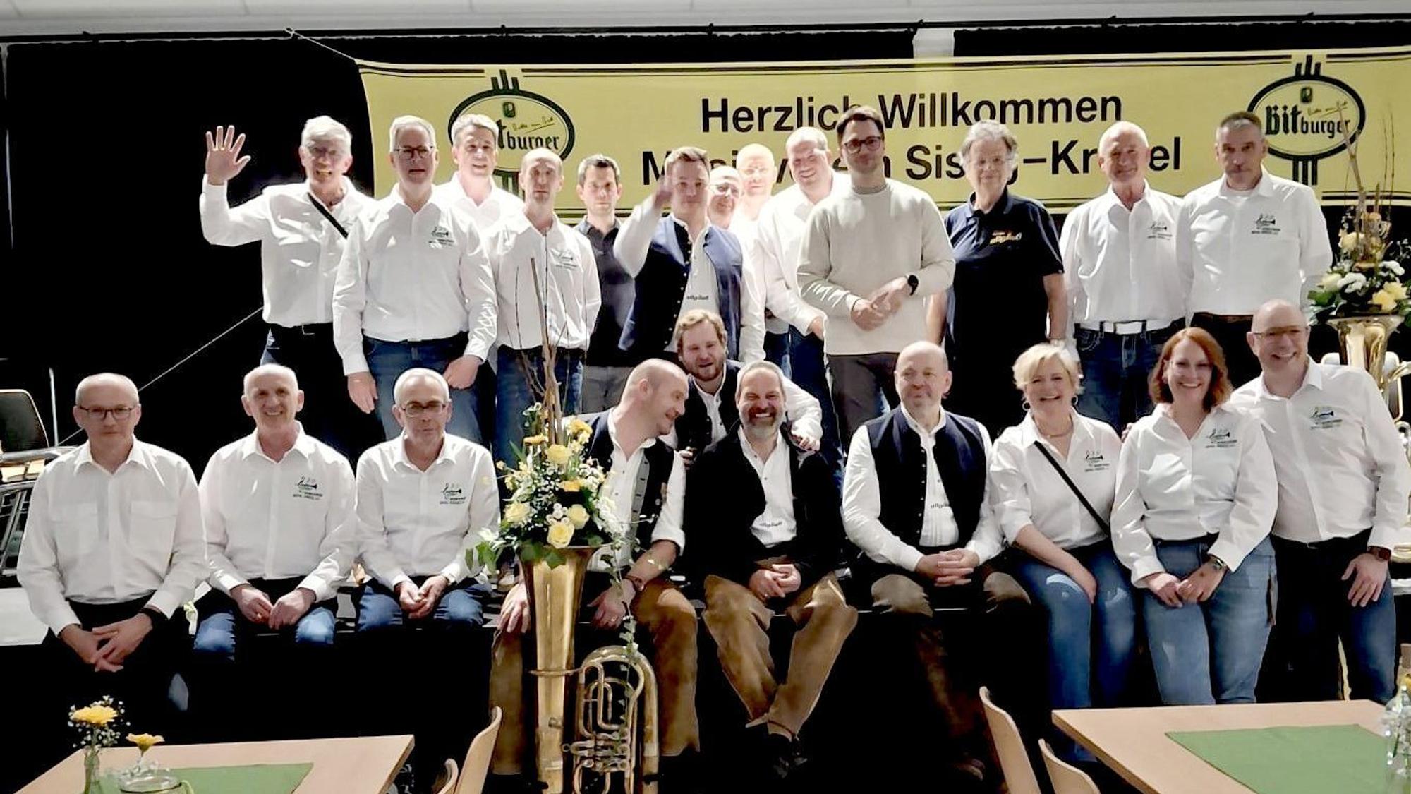 Die Musiker stehen oder sitzen auf der Bühne.