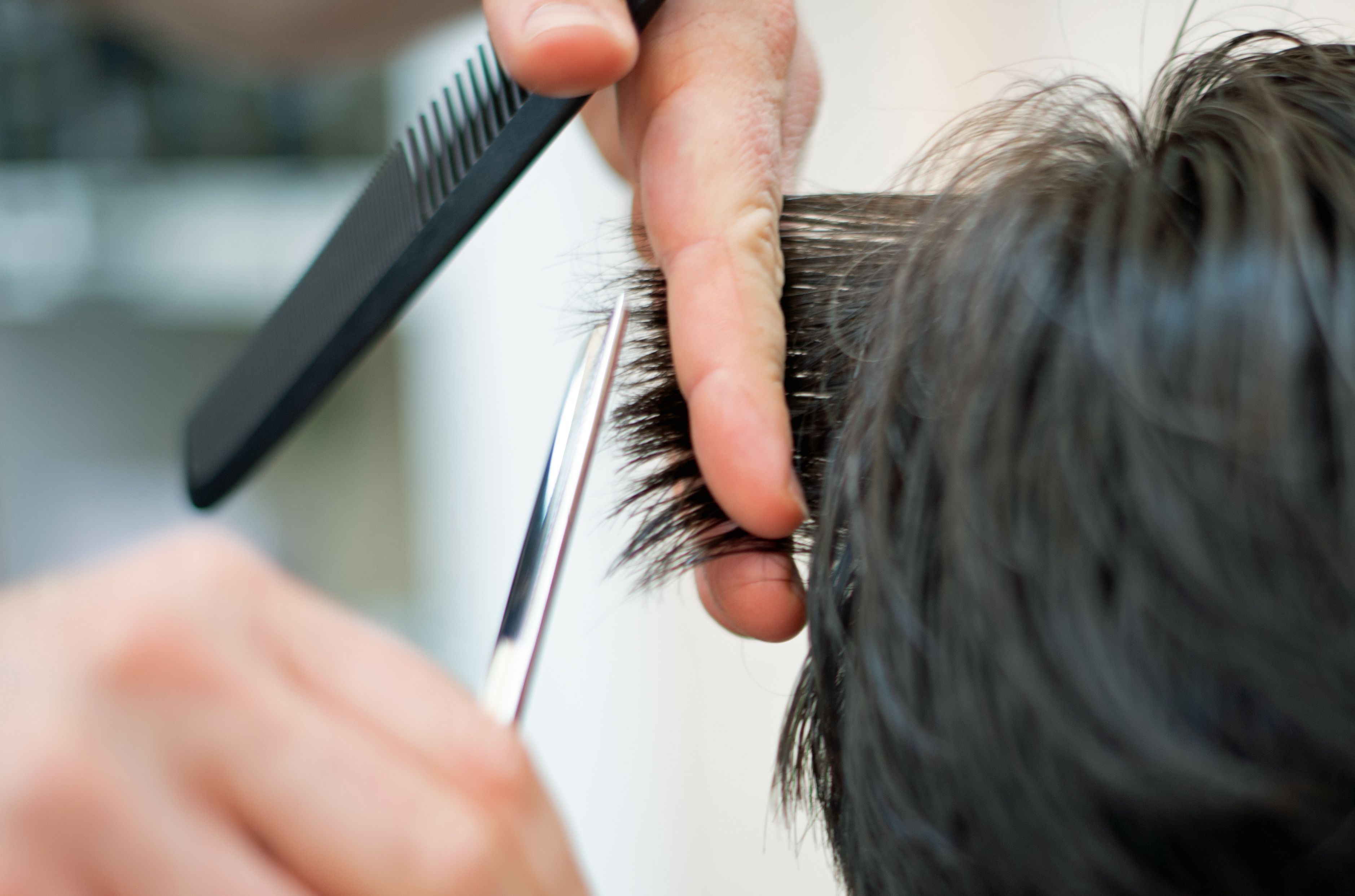 Ein Friseur schneidet in einem Friseur-Salon die Haare