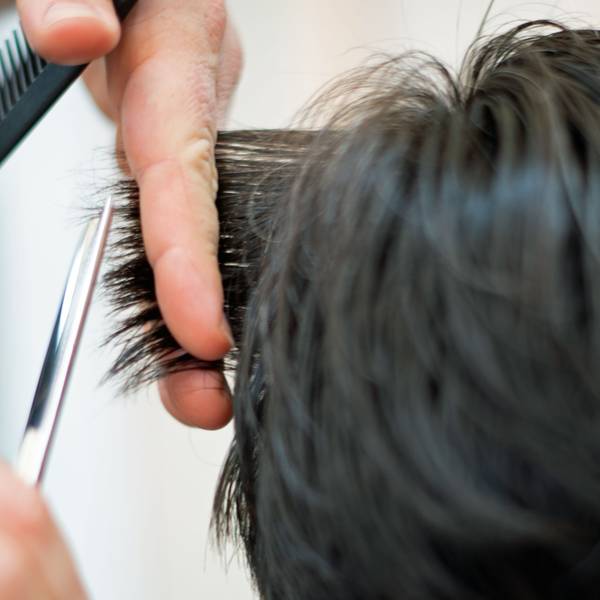 Ein Friseur schneidet in einem Friseur-Salon die Haare