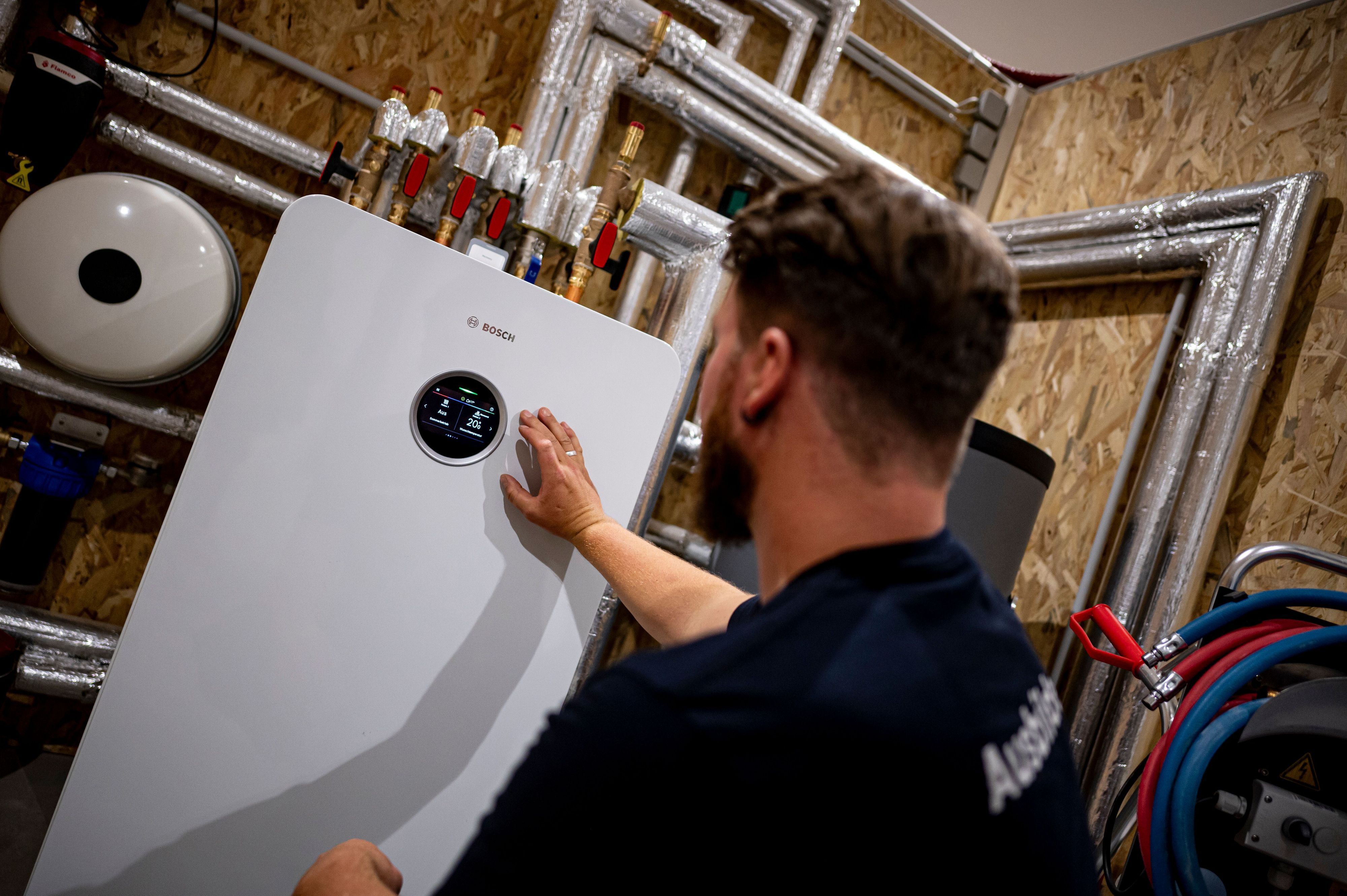 Ein Mann arbeitet an einer Wärmepumpe.