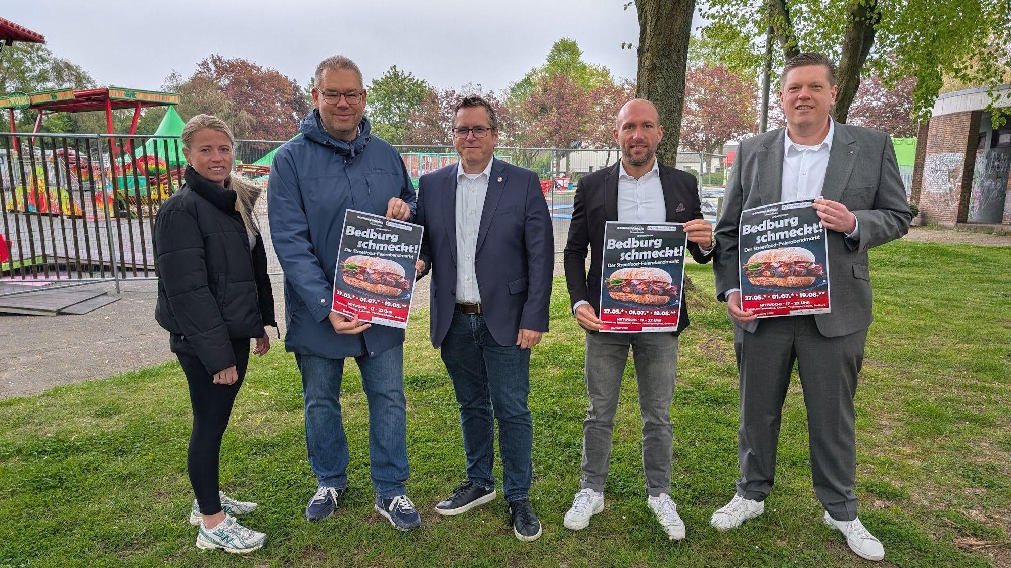 Marc Pesch, Lisa Niessen (beide Organisation Streetfood-Markt), Sascha Solbach (Bürgermeister der Stadt Bedburg), Dennis Blömer (Verkaufsleitung Autohaus Gottfried Schultz) und Martin Drösser (Regionalleiter Volksbank Erft) blicken mit Vorfreude auf die Bedburger Streetfood-Feierabendmärkte.