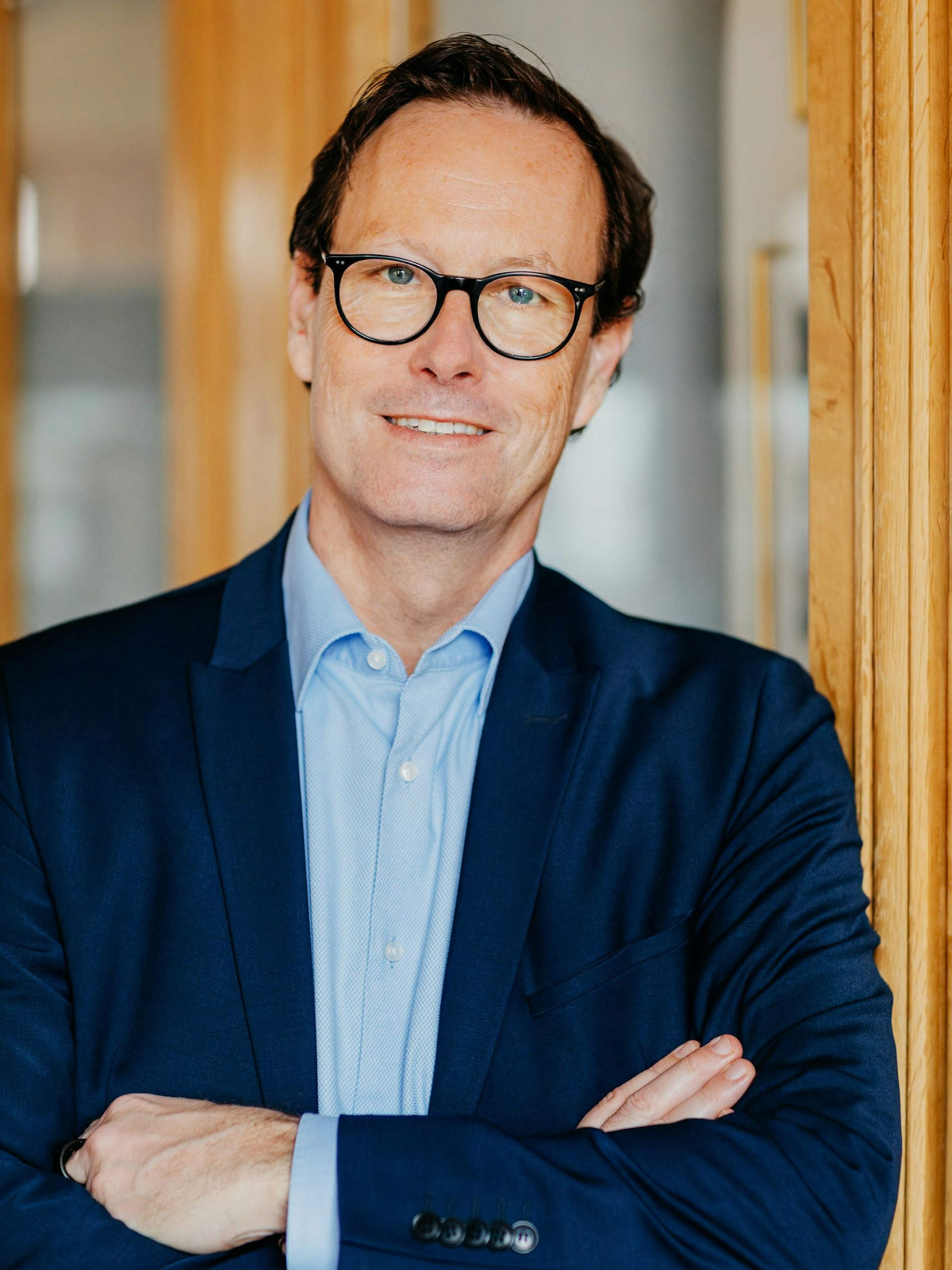 Herr Koch ist im Halbporträt zu sehen und lacht in die Kamera.