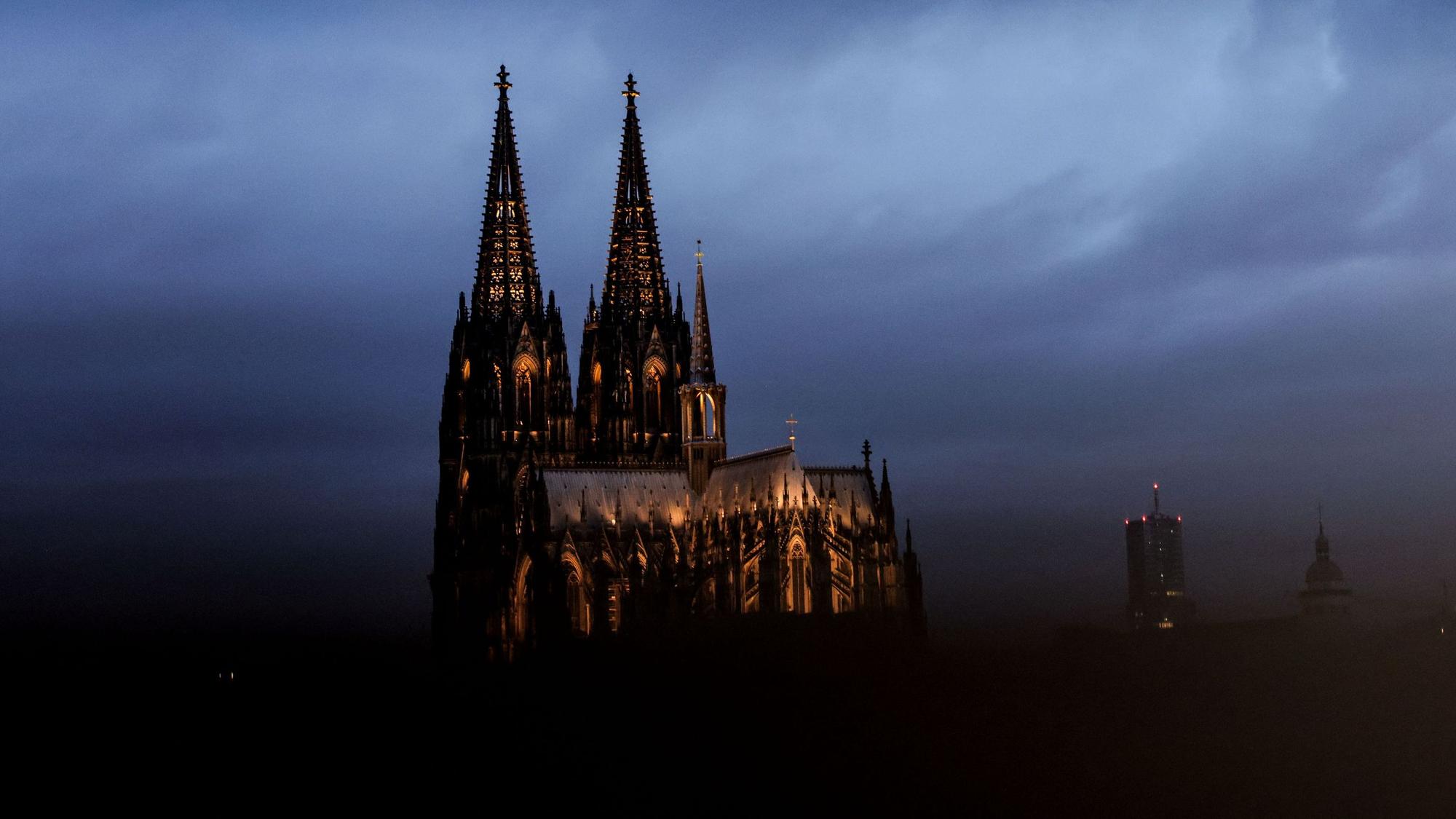 Der Dom ist am Morgen durch ein Geländer gesehen angestrahlt. (zu dpa: «Kölner Dom kostet Touristen künftig Eintritt») +++ dpa-Bildfunk +++