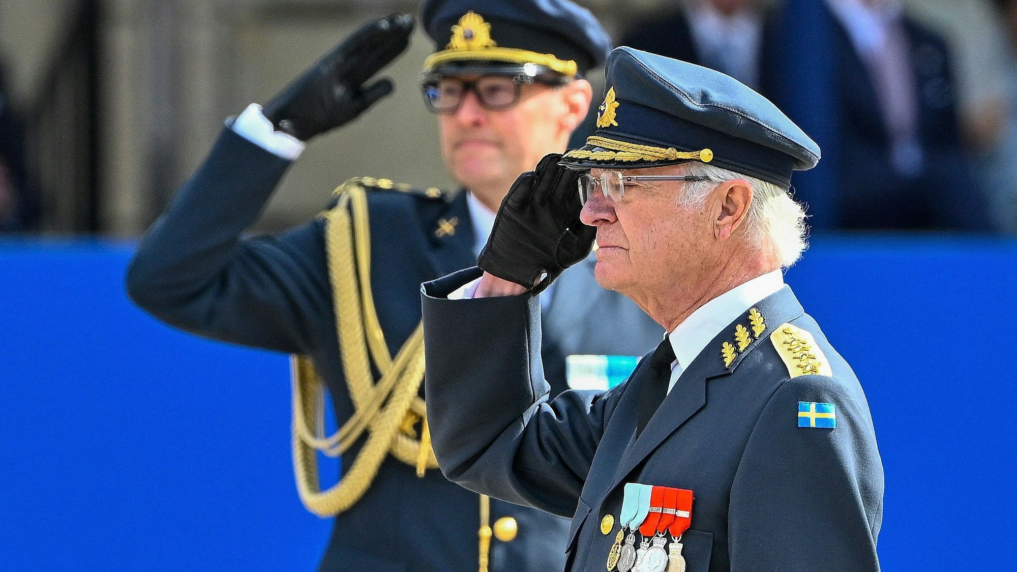 König Carl XVI. Gustaf salutiert während des Wachwechsels im Außenhof des Stockholmer Schlosses, während die schwedischen Streitkräfte den Monarchen ehren.