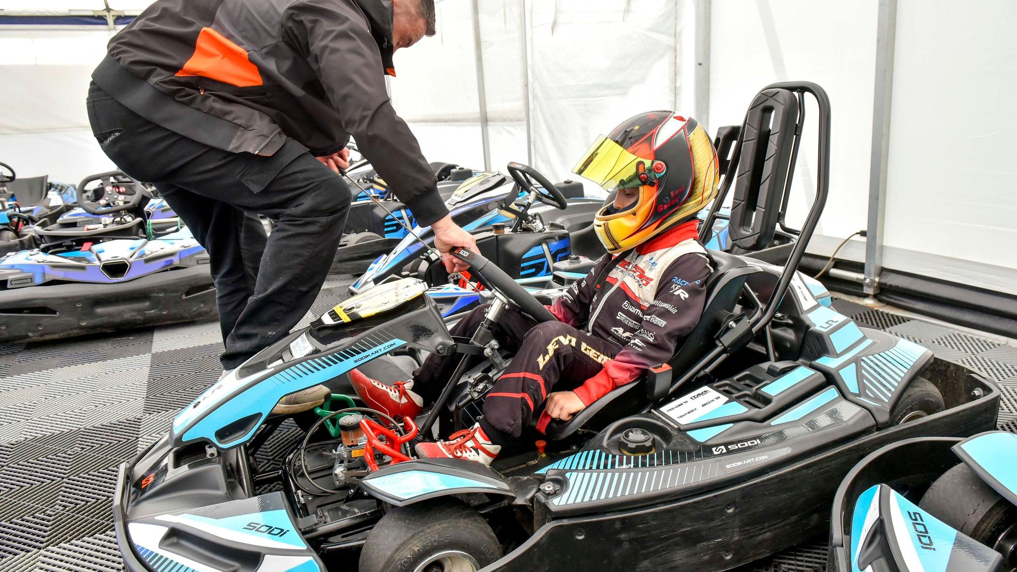 Das Foto zeigt einen Jungen, der in einem Kart sitzt.