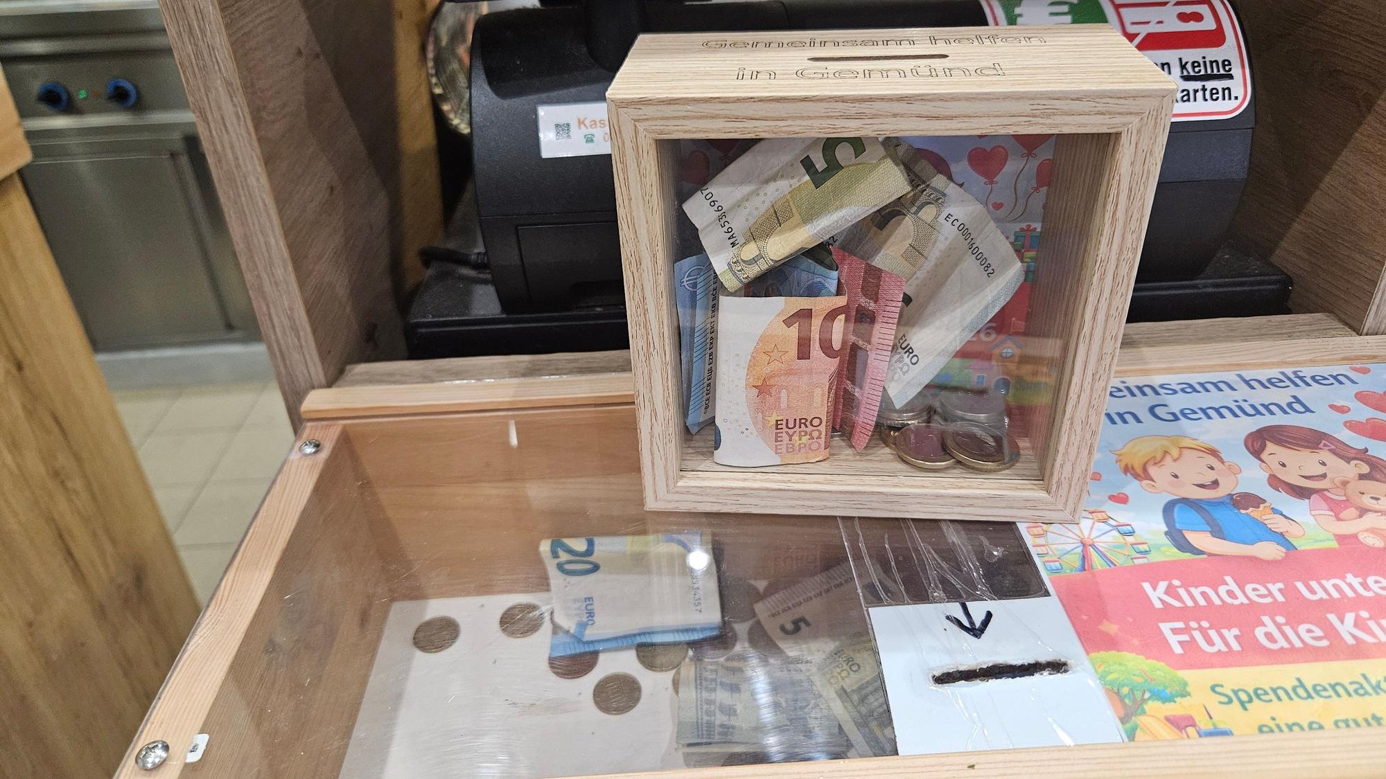 Das Bild zeigt zwei Boxen mit Geldscheinen und Münzgeld.