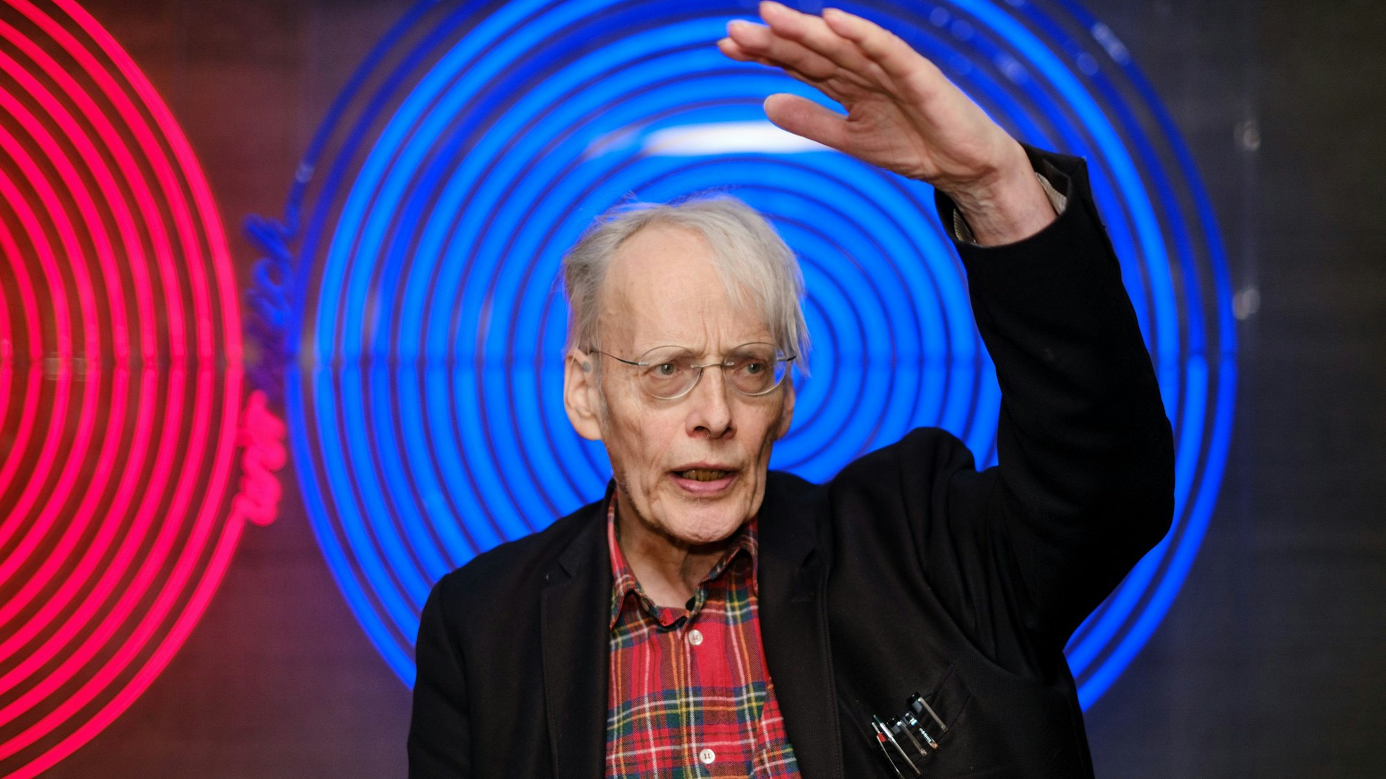 Timm Ulrichs steht vor zwei Leuchtkörpern.