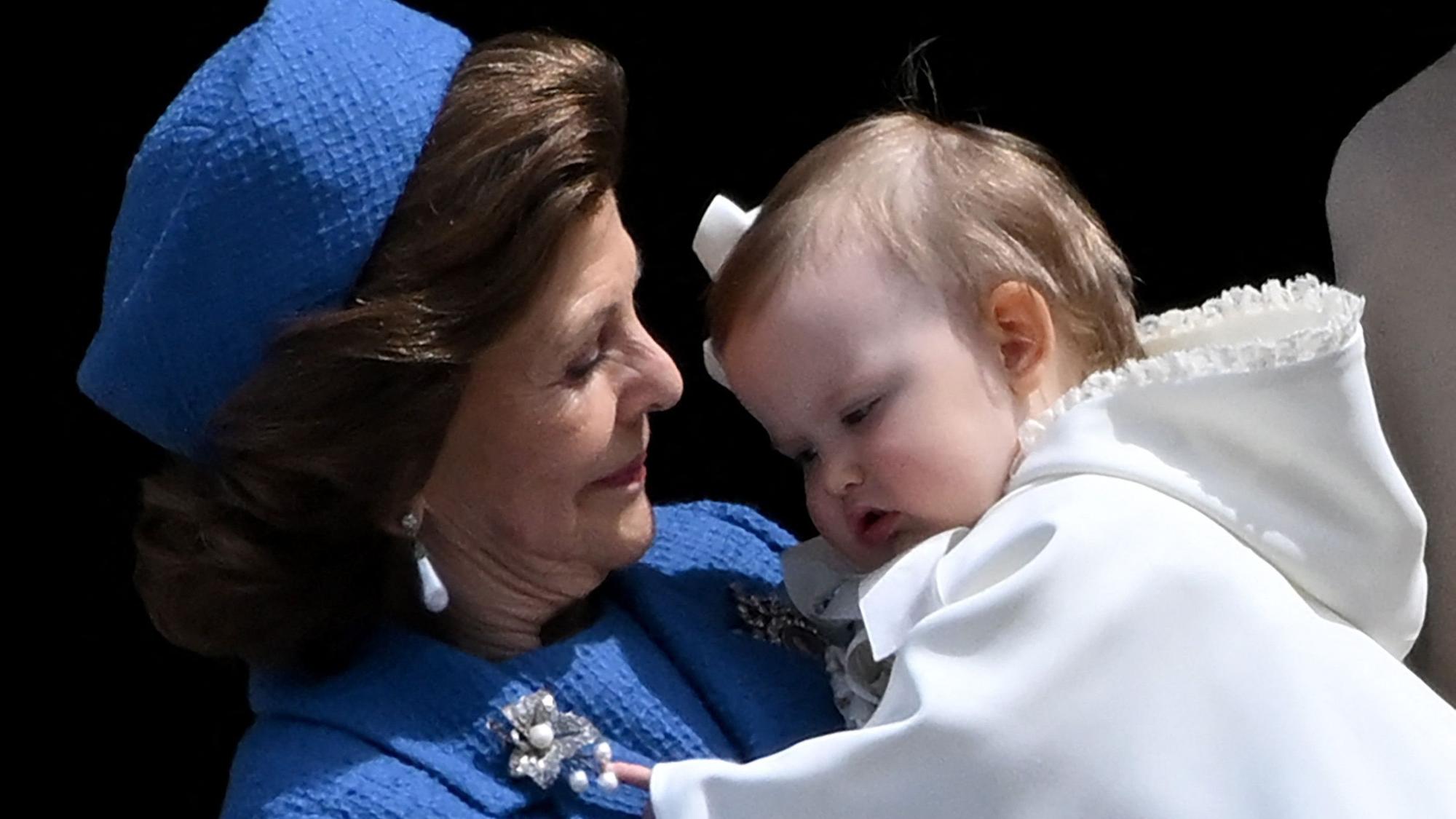Königin Silvia von Schweden hält Prinzessin Ines Marie Lilian Silvia im Arm, während sie gemeinsam auf dem Balkon des Königlichen Schlosses verweilen.