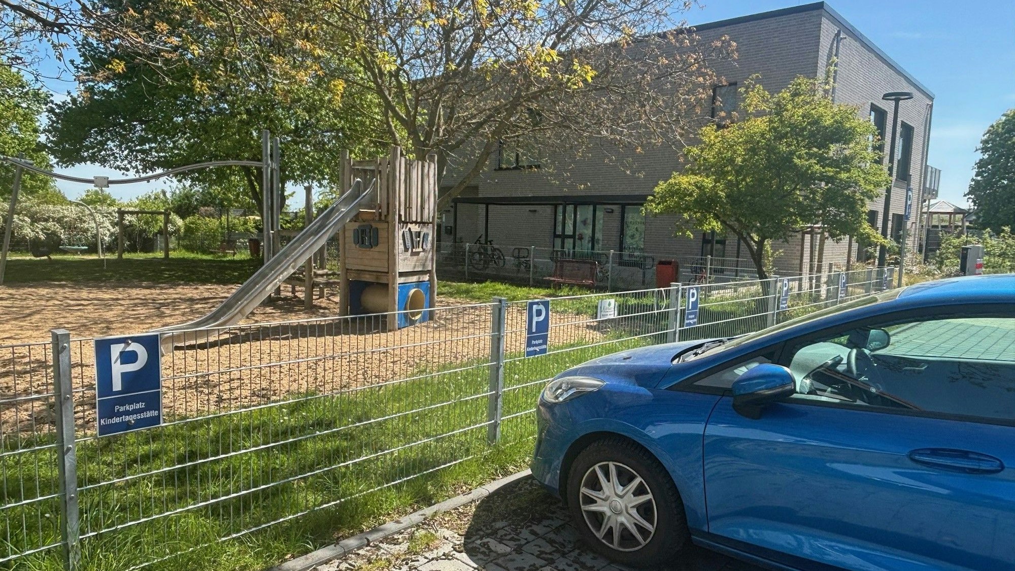 Auf einem Parkstreifen vor der Kita in Wißkirchen parkt ein blaues Auto.