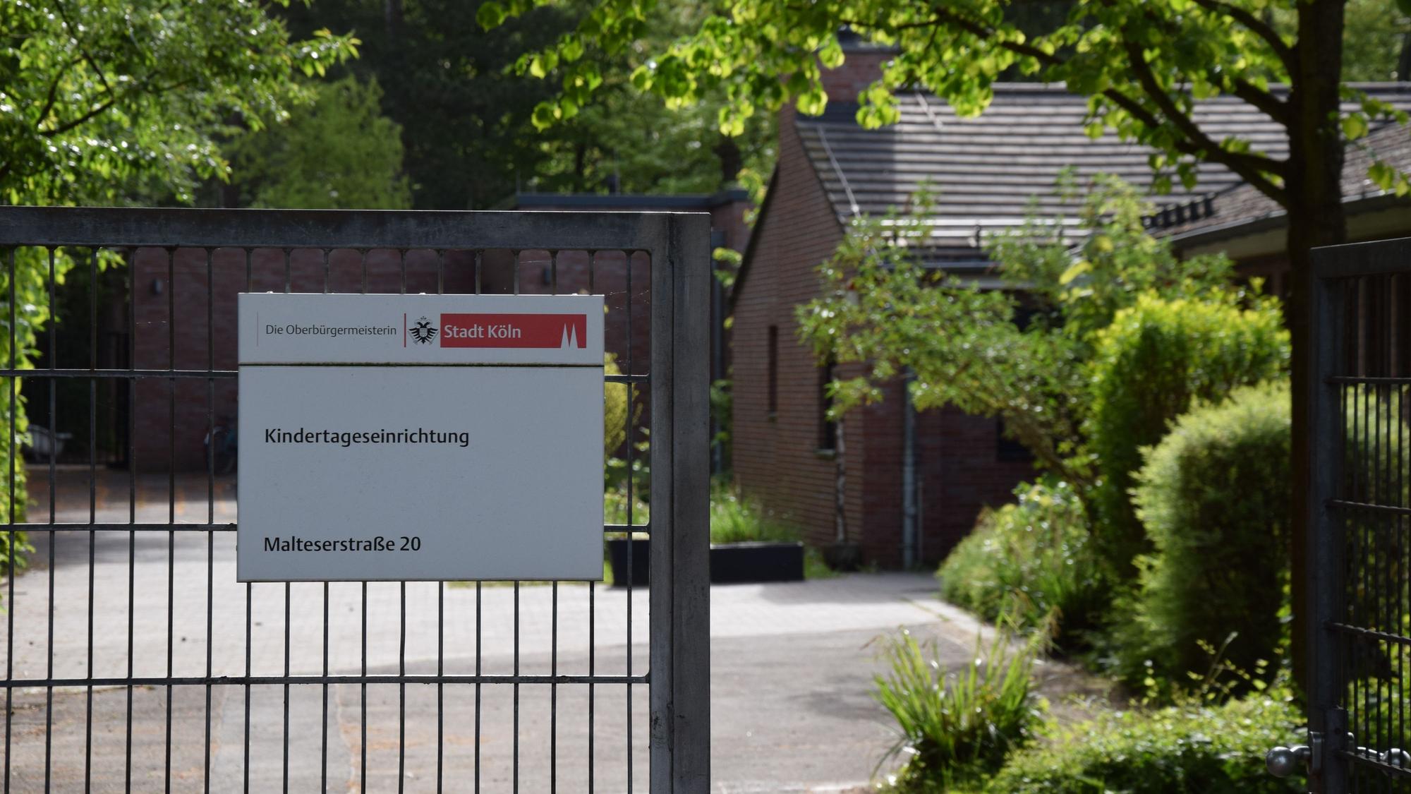 An einem Gittertor hängt ein Schild: Kindertageseinrichtung Malteserstraße 20.