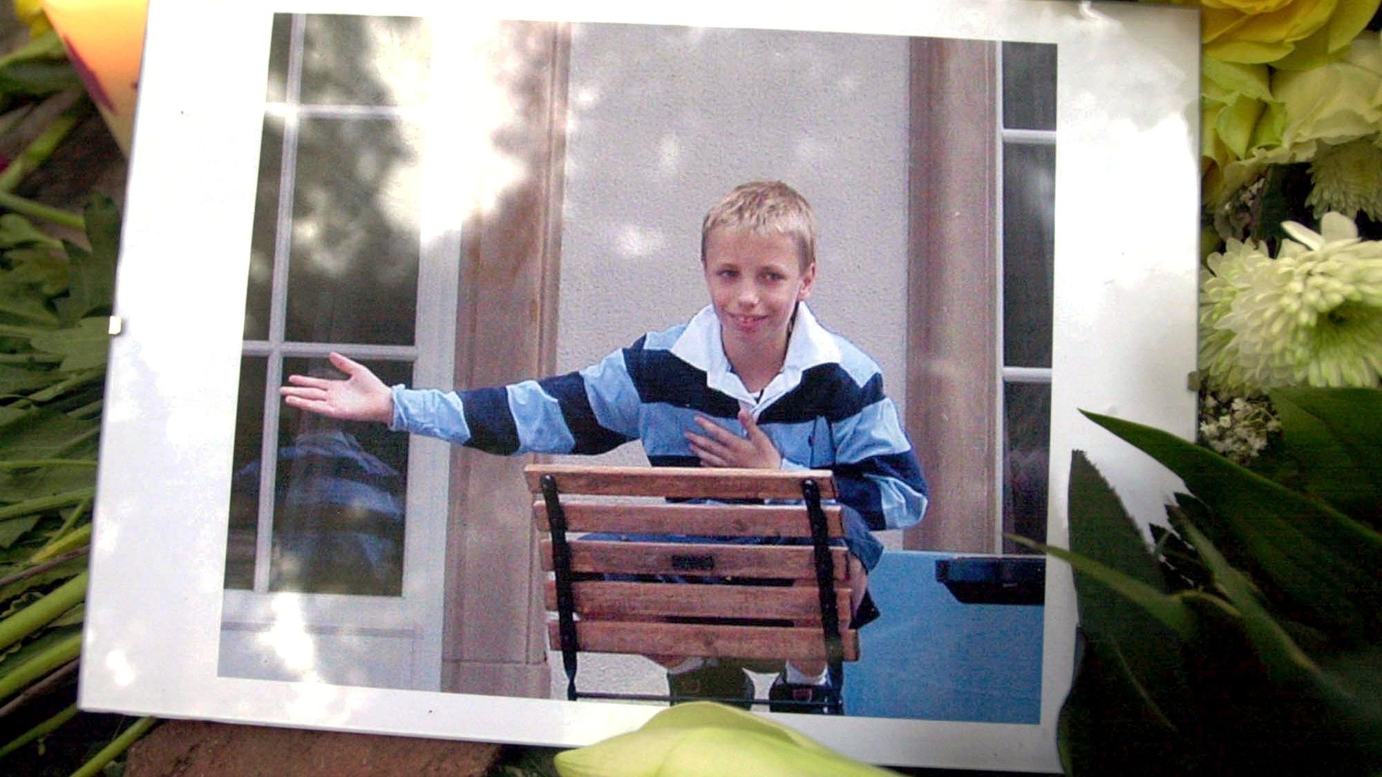 Inmitten von Blumengestecken und Kerzen liegt 2002 vor dem Elternhaus des Mordopfers in Frankfurt am Main ein Bild des ermordeten Jakob von Metzler.