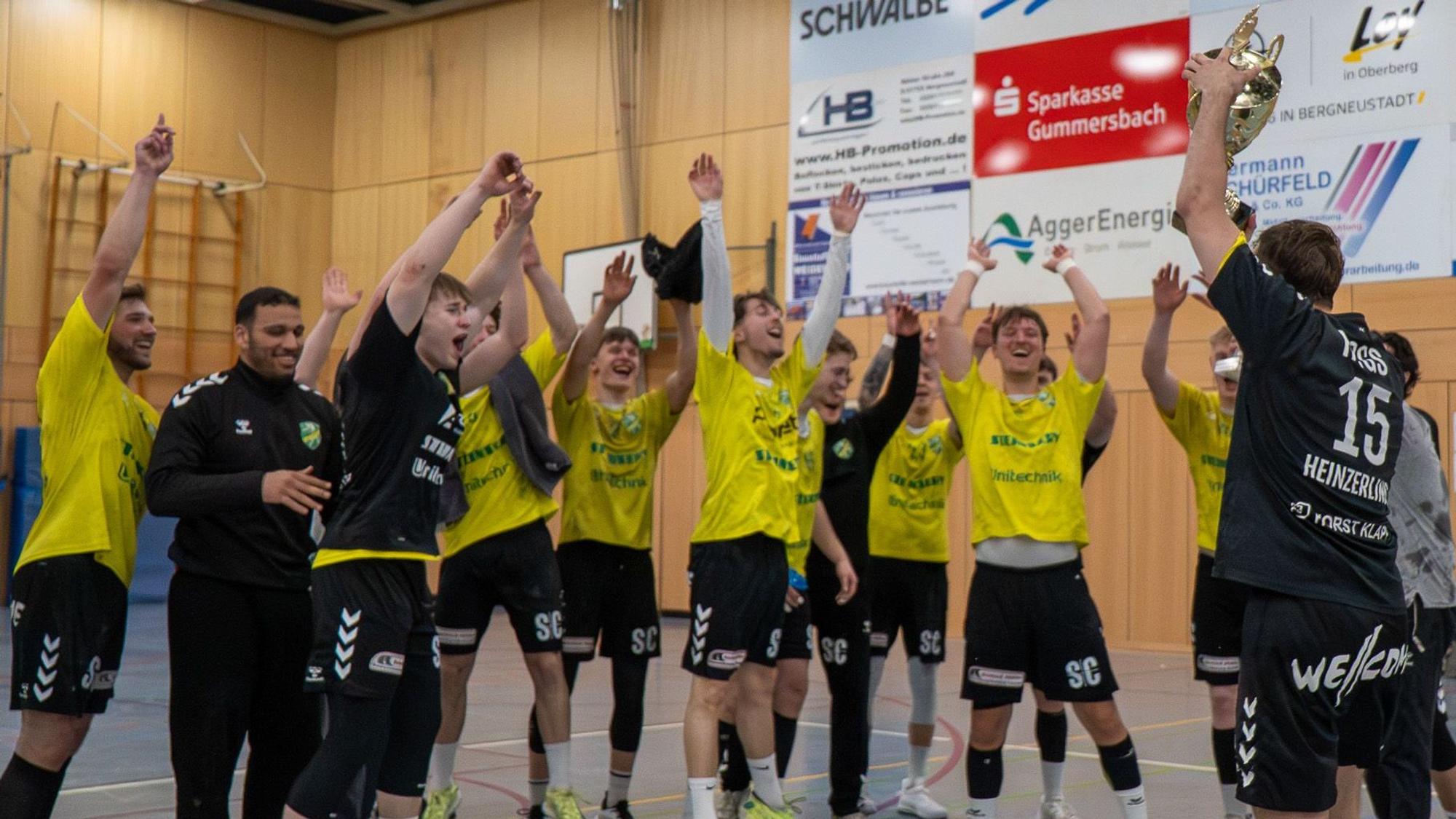 Die Handballer jubeln mit den Händen zum Himmel.
