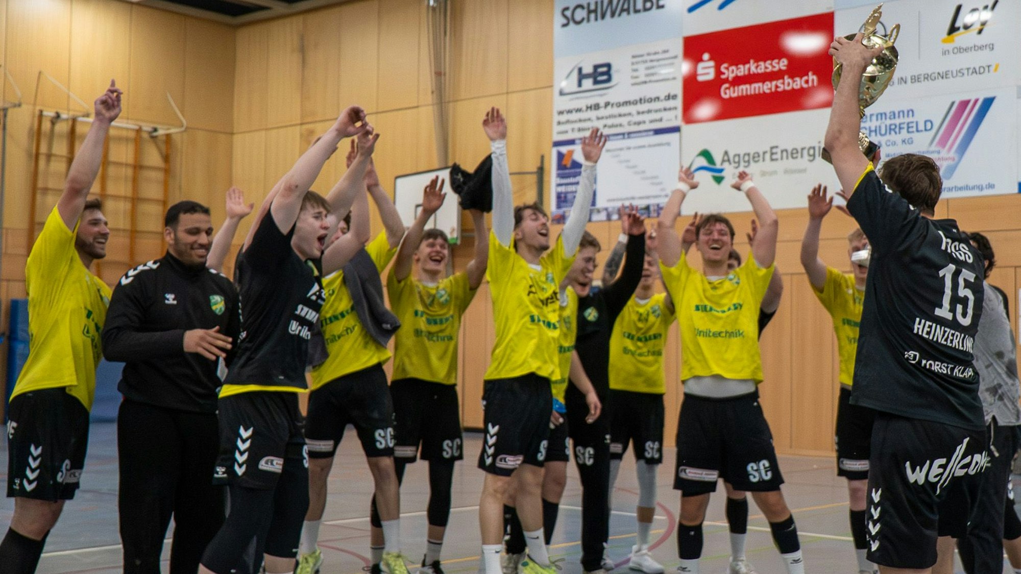 Die Handballer jubeln mit den Händen zum Himmel.