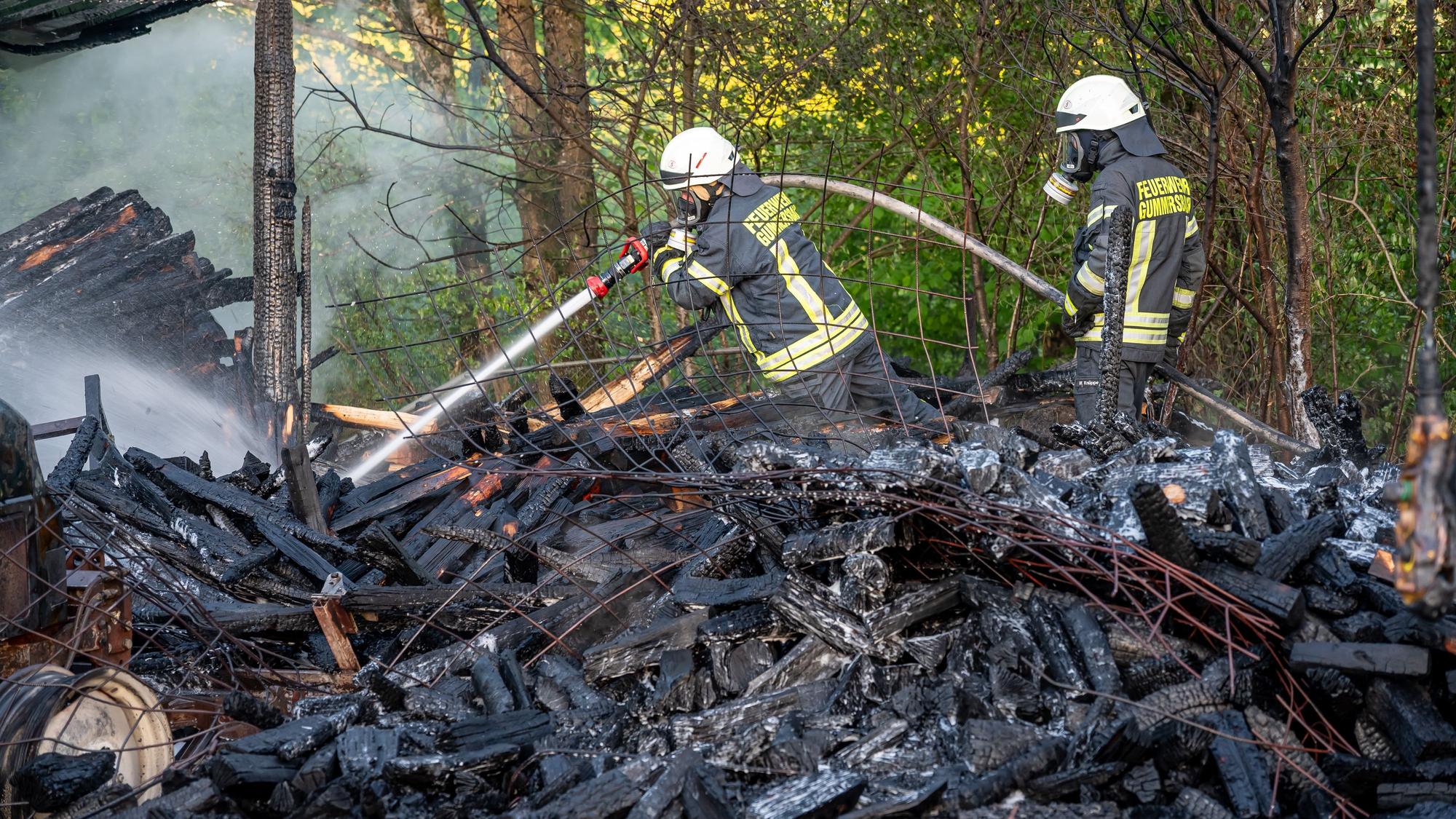 Feuerwehrleute löschen einen Schuppenbrand.