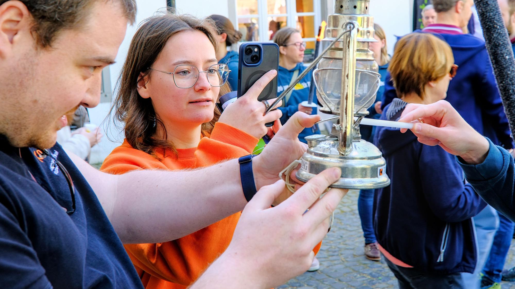 Das Foto zeigt, wie die Flamme weitergereicht wird