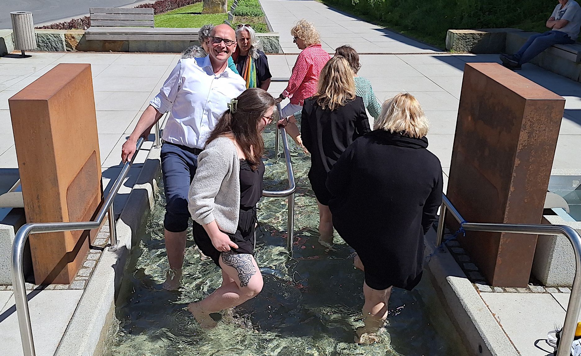 Eine Gruppe von Menschen beim Wassertreten, darunter auch der Bürgermeister.
