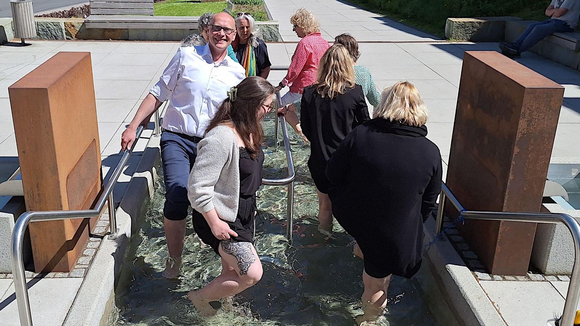 Eine Gruppe von Menschen beim Wassertreten, darunter auch der Bürgermeister.