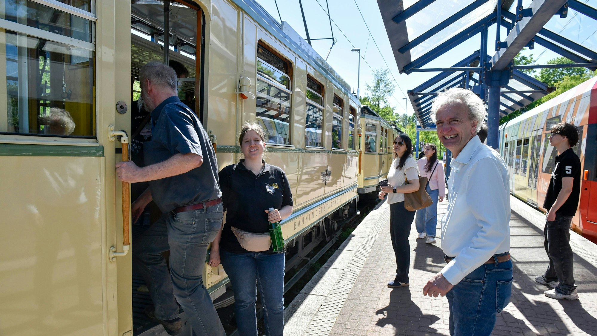 Auf dem Bild sind Personen zu sehen, die in die historische Straßenbahn einsteigen.