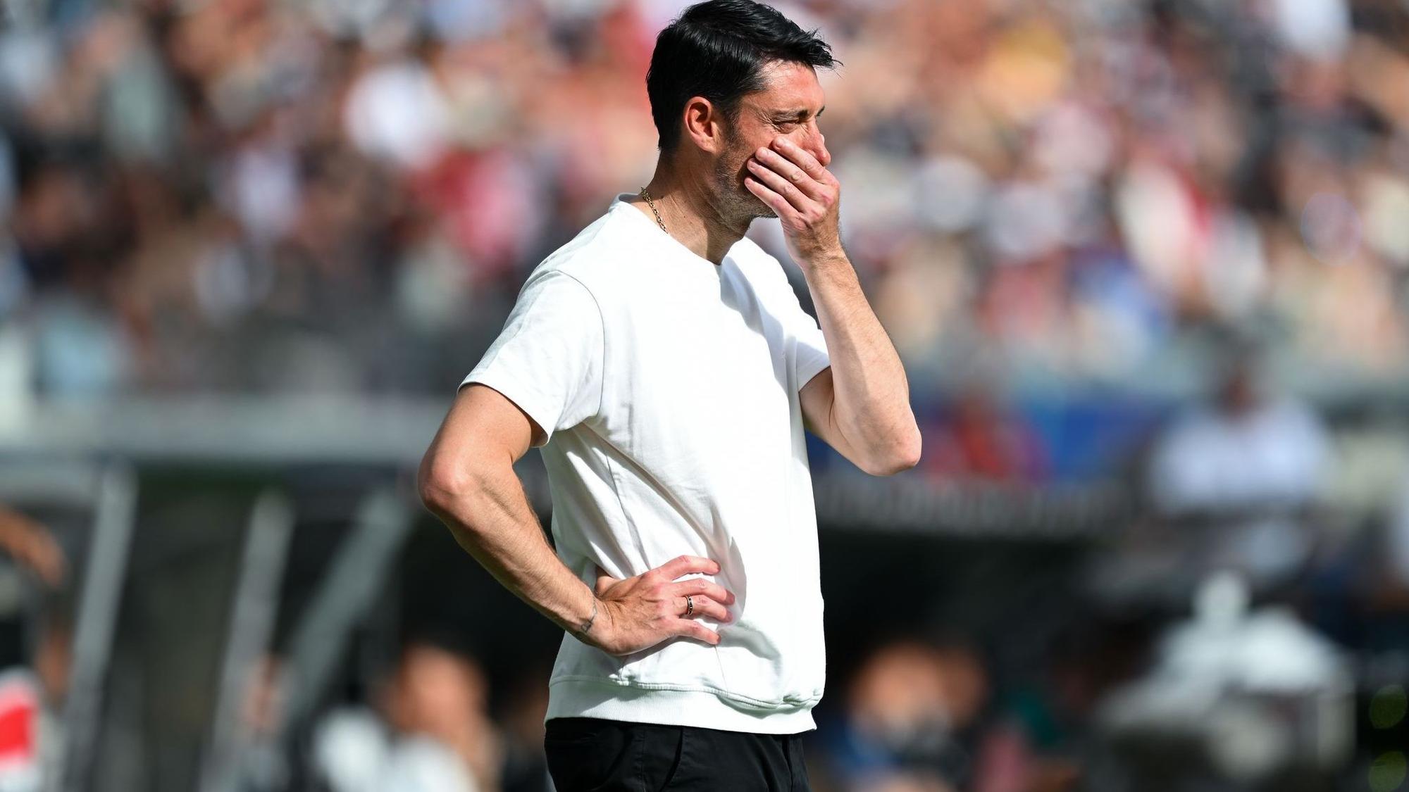 Trainer Albert Riera von Eintracht Frankfurt steht nachdenklich am Spielfeldrand.