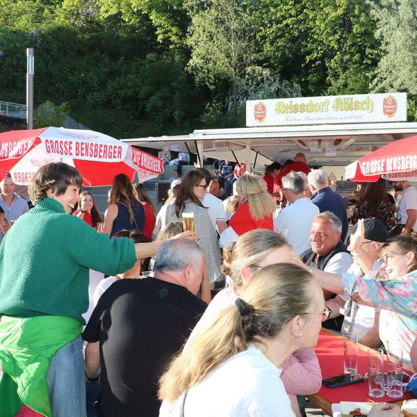 Menschen an Biertischen in der Sonne