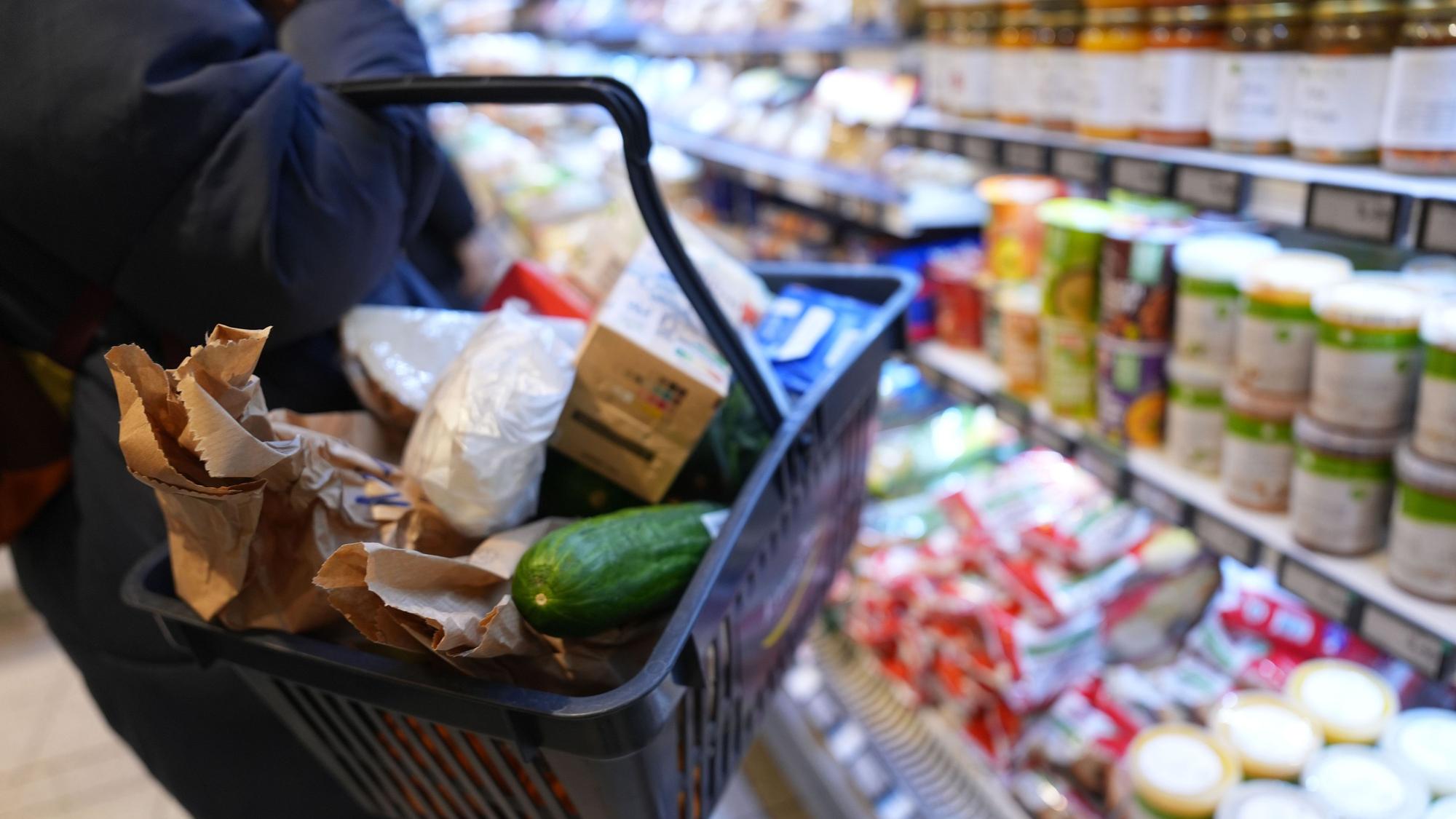 Das Foto zeigt eine Frau vor einem Supermarkt-Regal