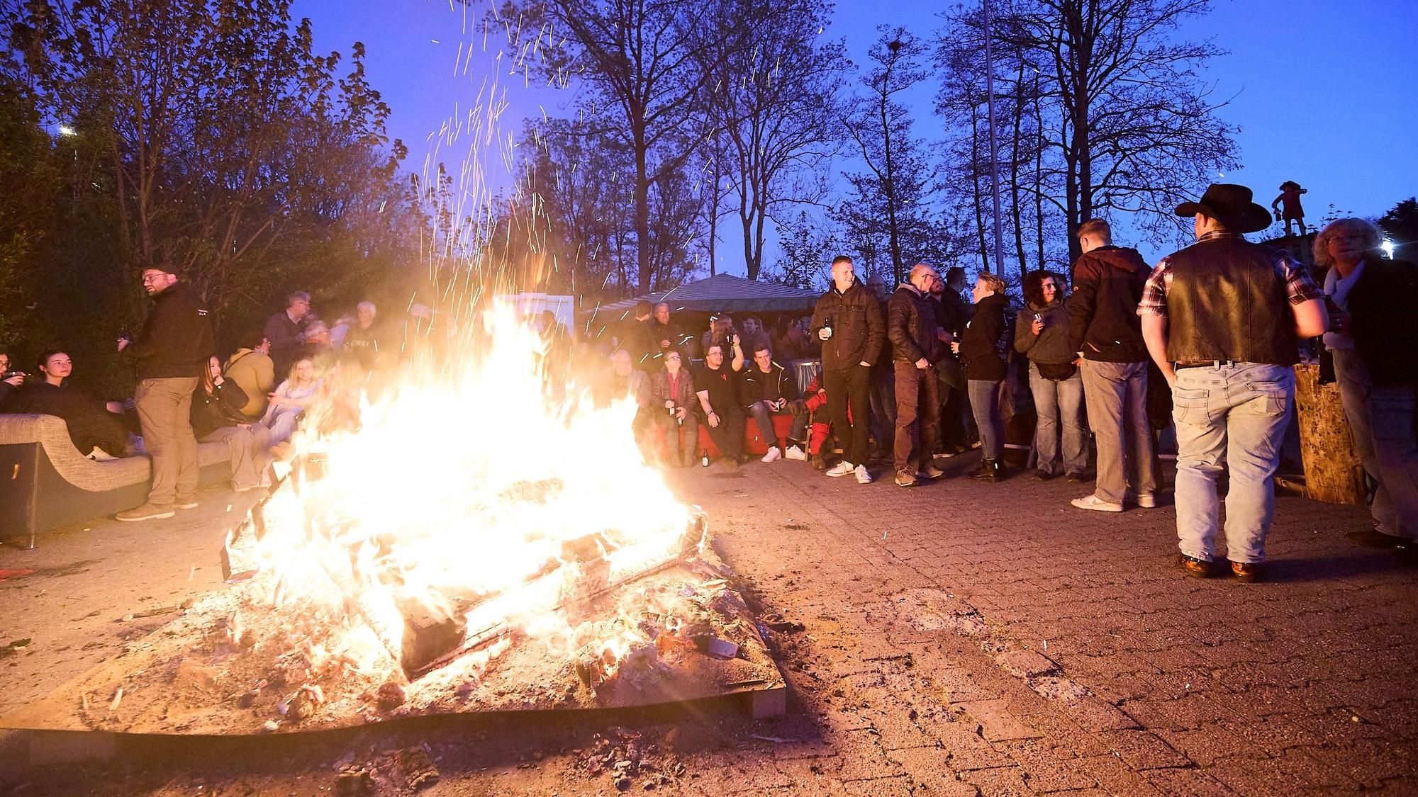 Um das hell lodernde Feuerwehr haben sich viele junge Leute geschart.