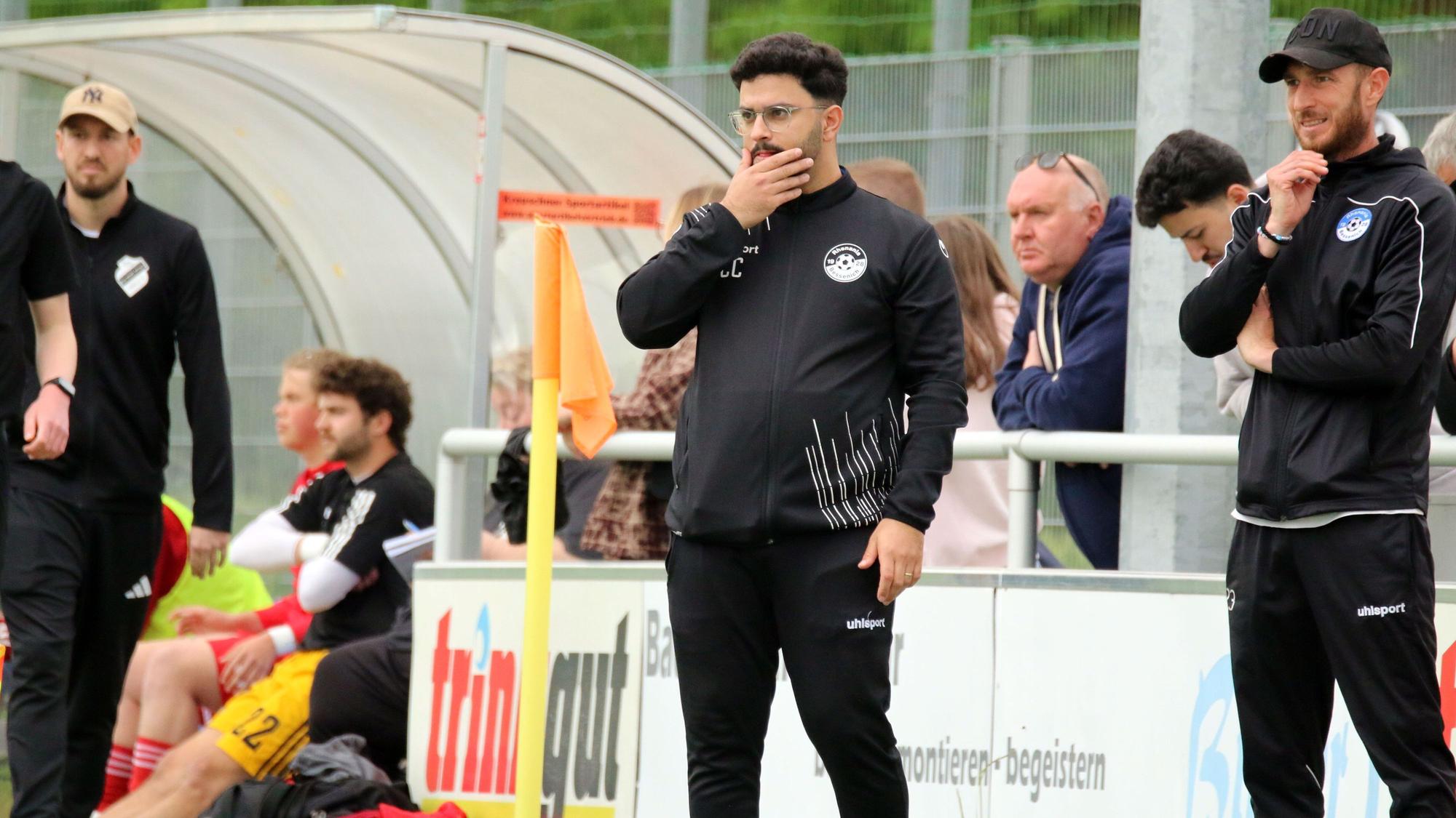 Bessenichs Trainer Can Celik greift sich mit der Hand ins Gesicht. Neben ihm steht Ex-Profi Moritz Hartmann.