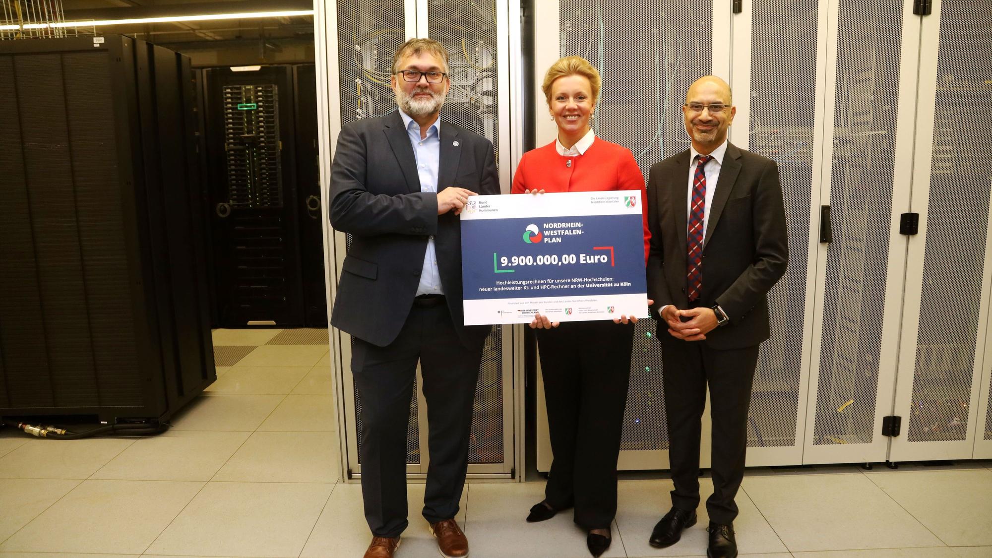 Mehr Rechenpower für KI: Die Universität zu Köln baut das Hochleistungsrechnen für nordrhein-westfälische Hochschulen aus. Ministerin Ina Brandes überreicht der Uni eine Förderzusage für ein High Performance Computing Basiscluster an Joybrato Mukherjee (rechts) und Stefan Wesner. Foto: Arton Krasniqi