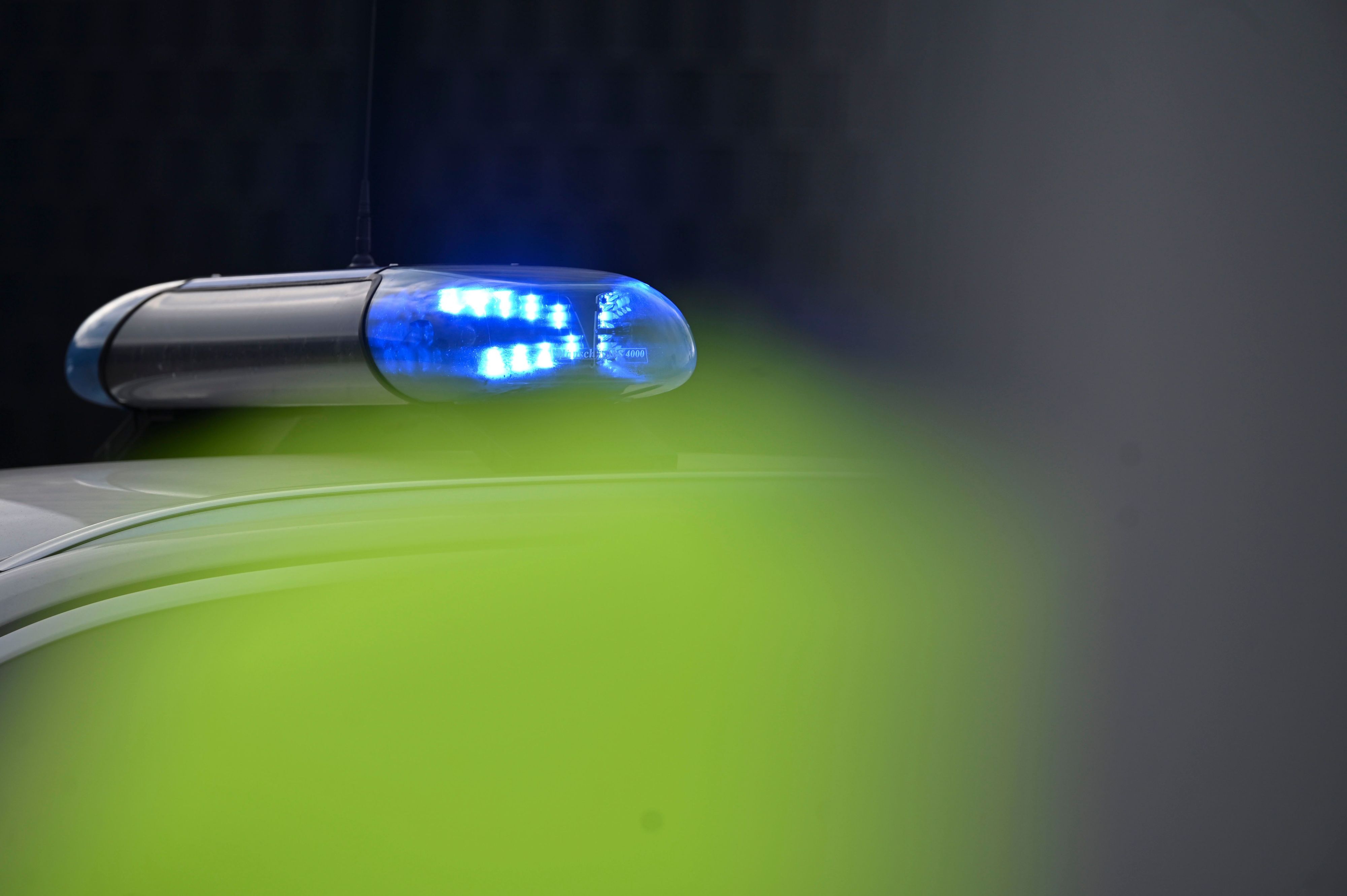 Ein Blaulicht leuchtet an einem Einsatzauto der Polizei.