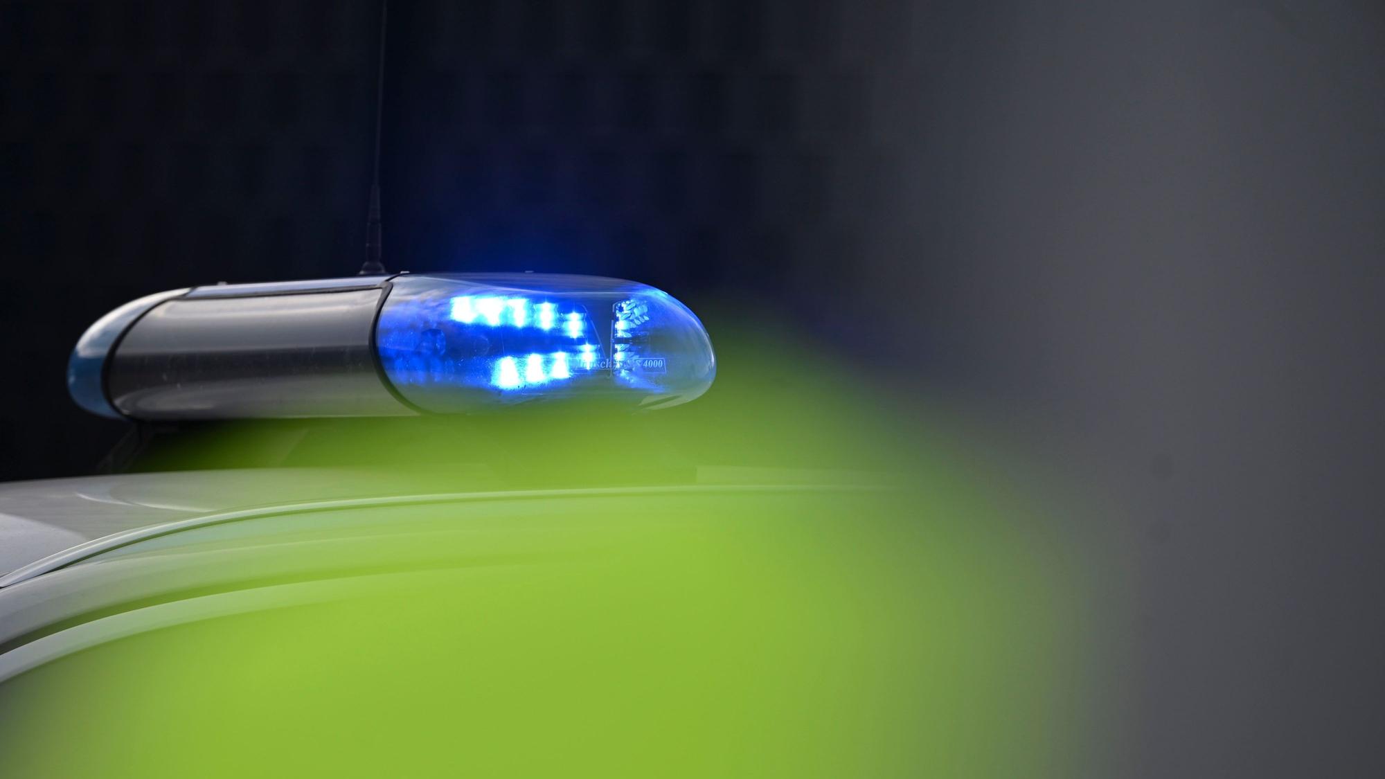 Ein Blaulicht leuchtet an einem Einsatzauto der Polizei.