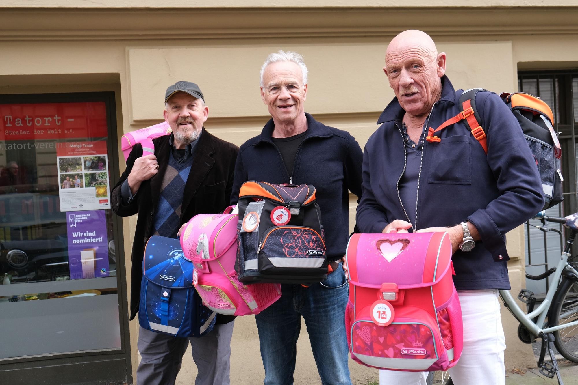 Die Tatort Köln-Schauspieler Dietmar Bär, Klaus J. Behrendt und Joe Bausch vom freuen sich über neue Schulranzen-Sets für Kölner Kinder.