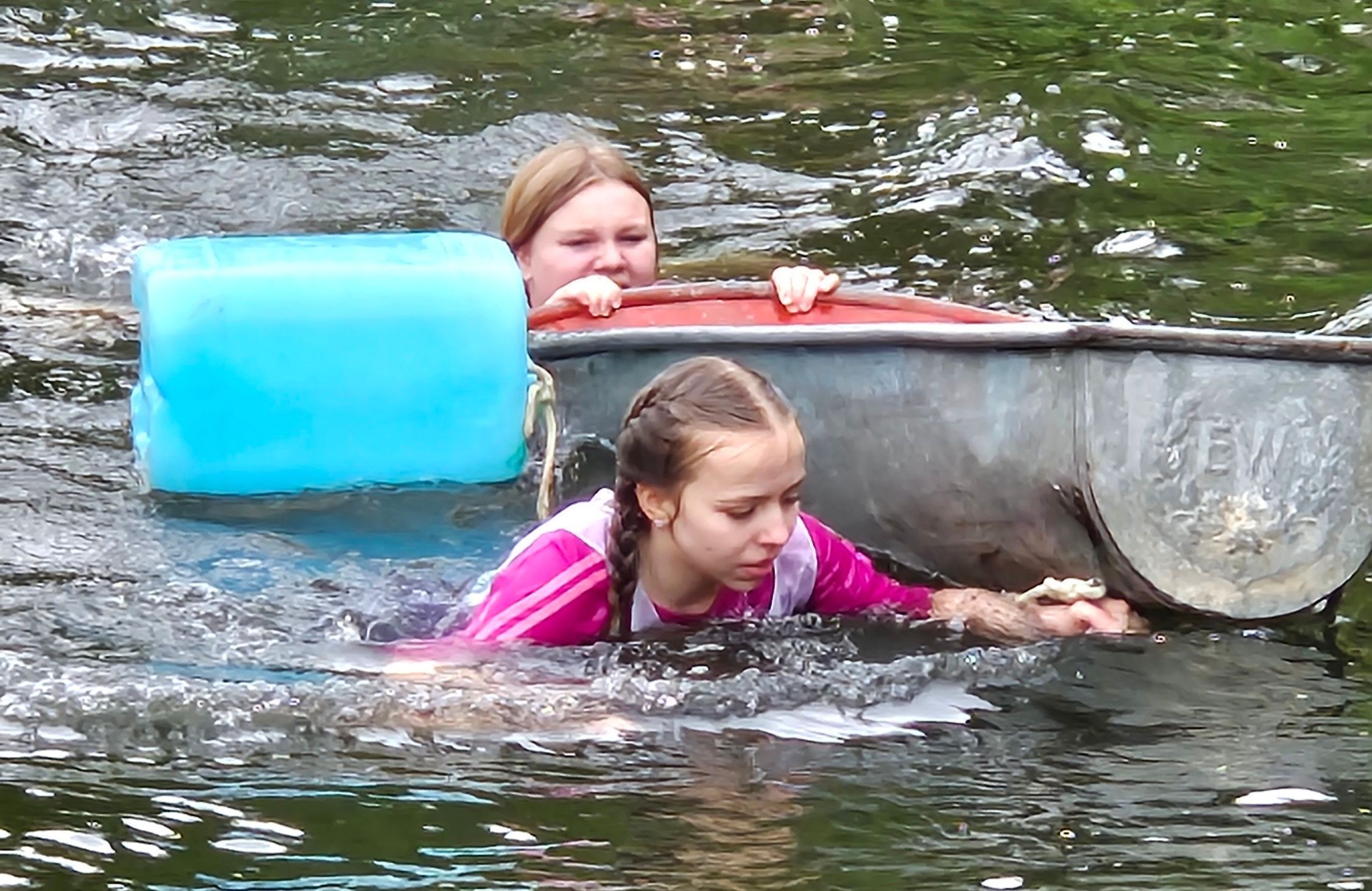 Zwei Mädchen schwimmen mit einer Badewanne in der Sülz.