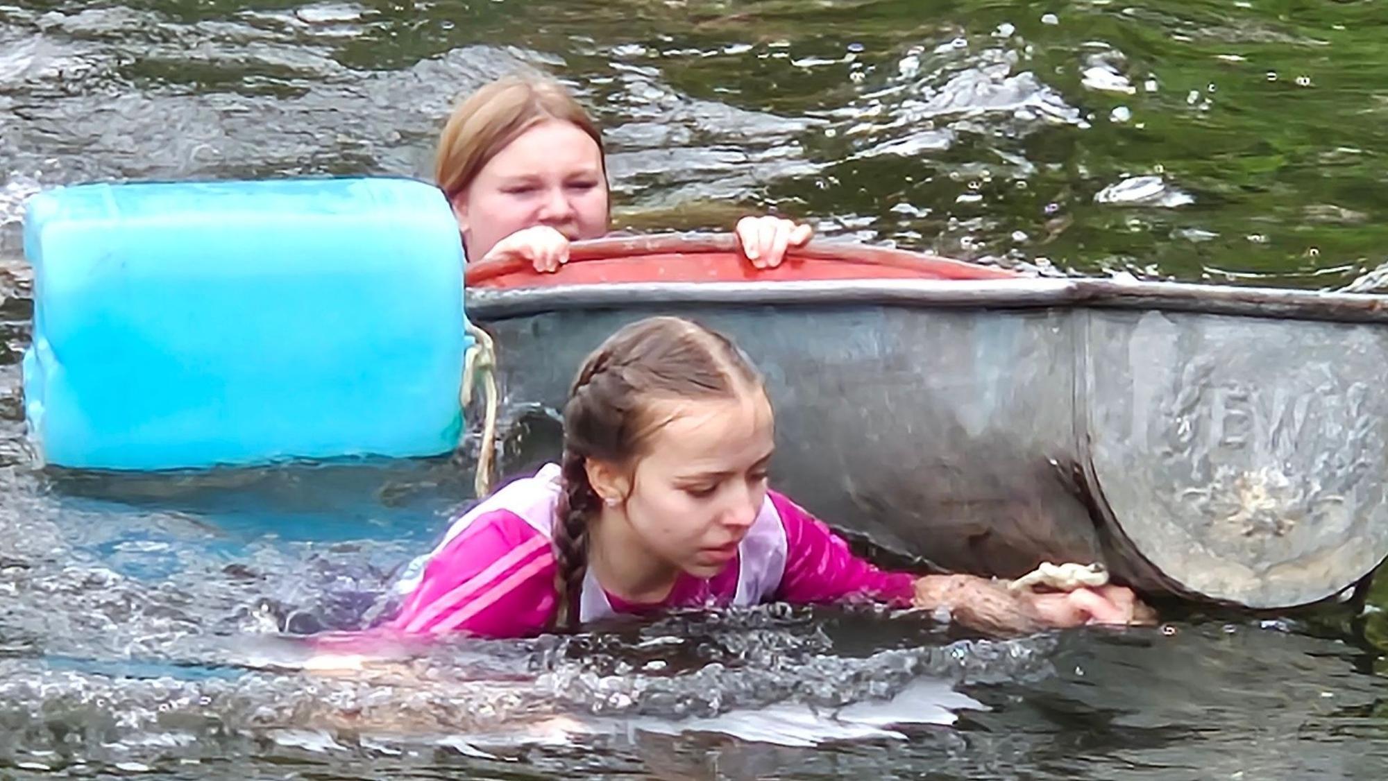 Zwei Mädchen schwimmen mit einer Badewanne in der Sülz.