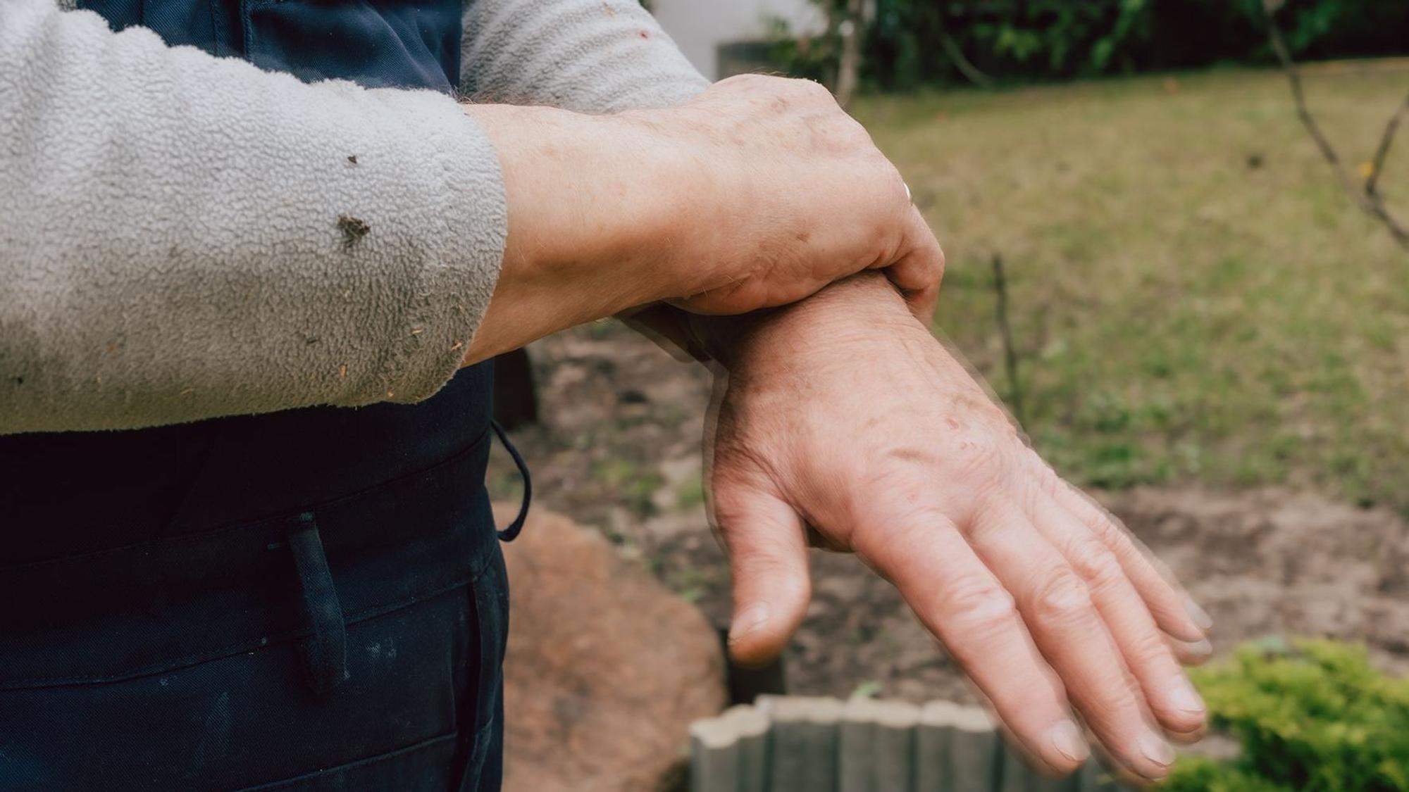 Zu sehen ist eine Hand, die ein Handgelenk umschließt.