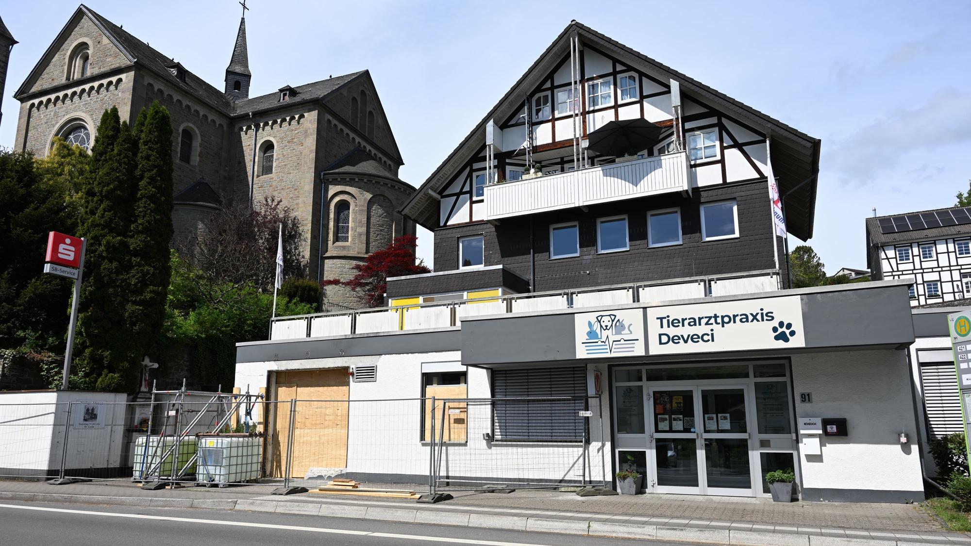 Zu sehen ist ein Gebäude mit Brettern anstelle von Fenstern und einem Bauzaun drumherum.