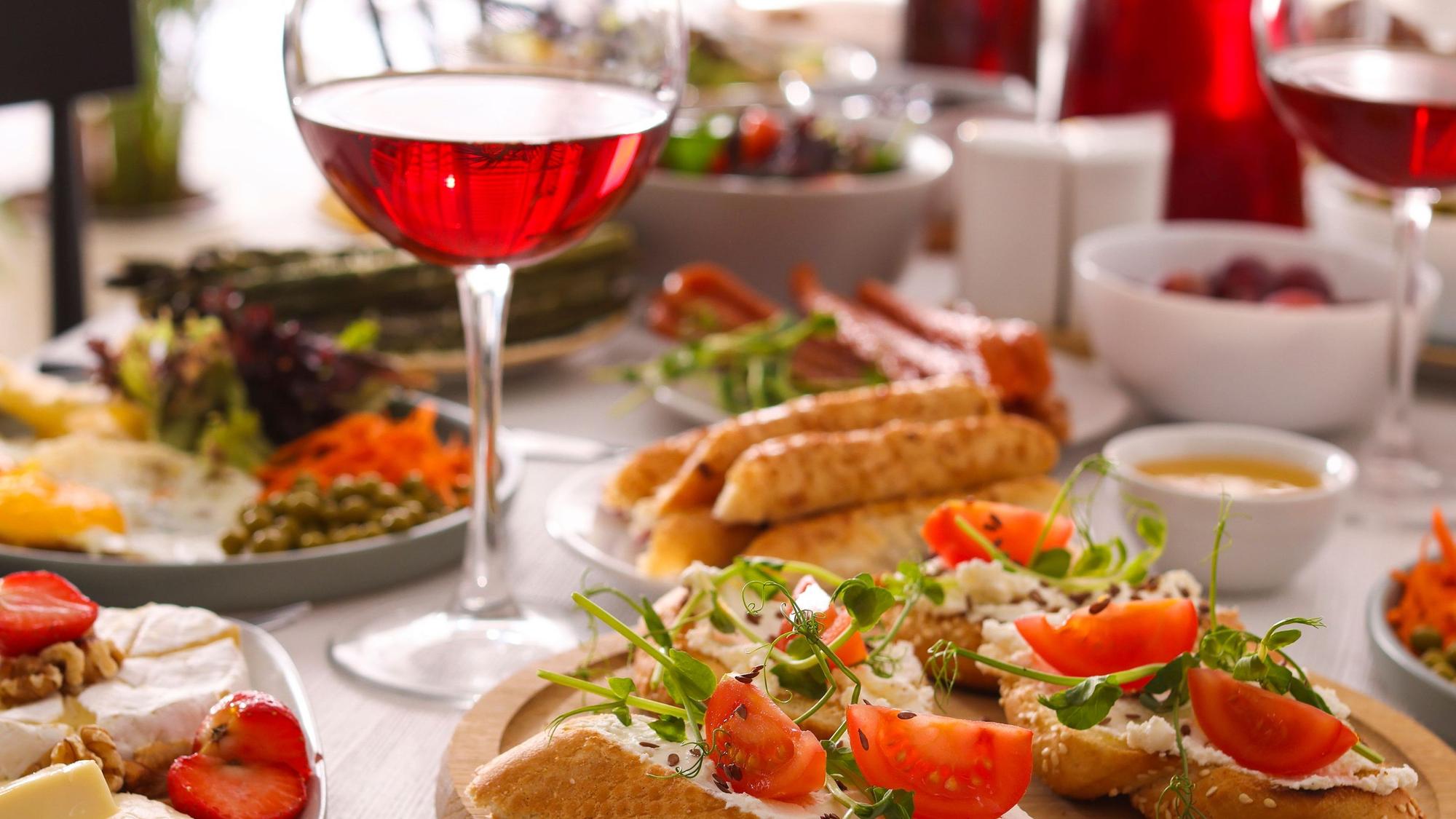 Auf einem Tisch stehen zum Brunch verschiedene Speisen und Getränke.