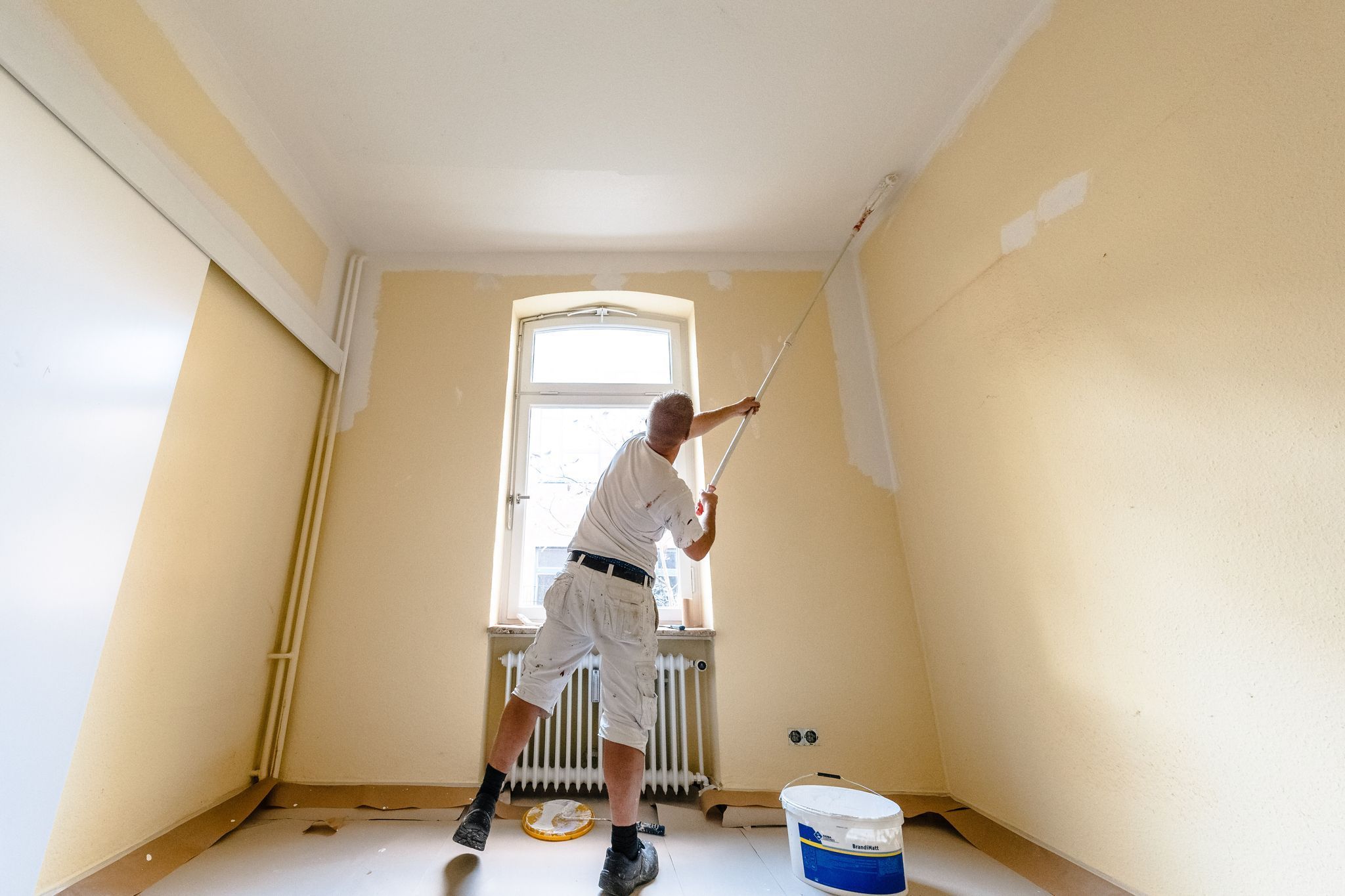 Maler streicht das Zimmer einer Wohnung