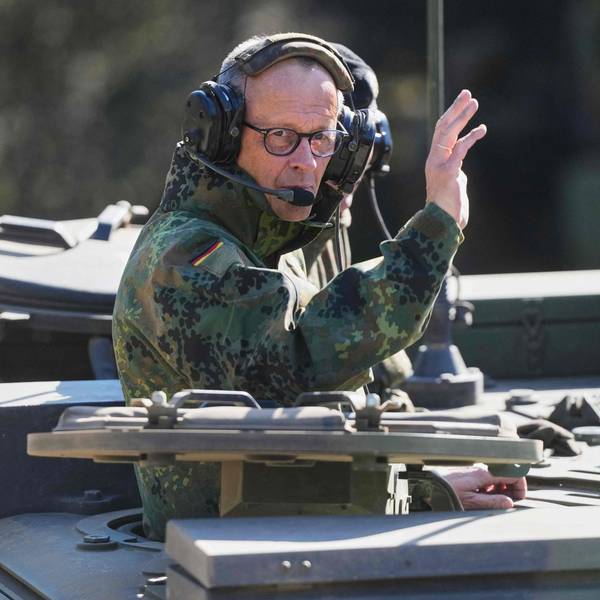 Bundeskanzler Friedrich Merz winkt aus einem Panzer.