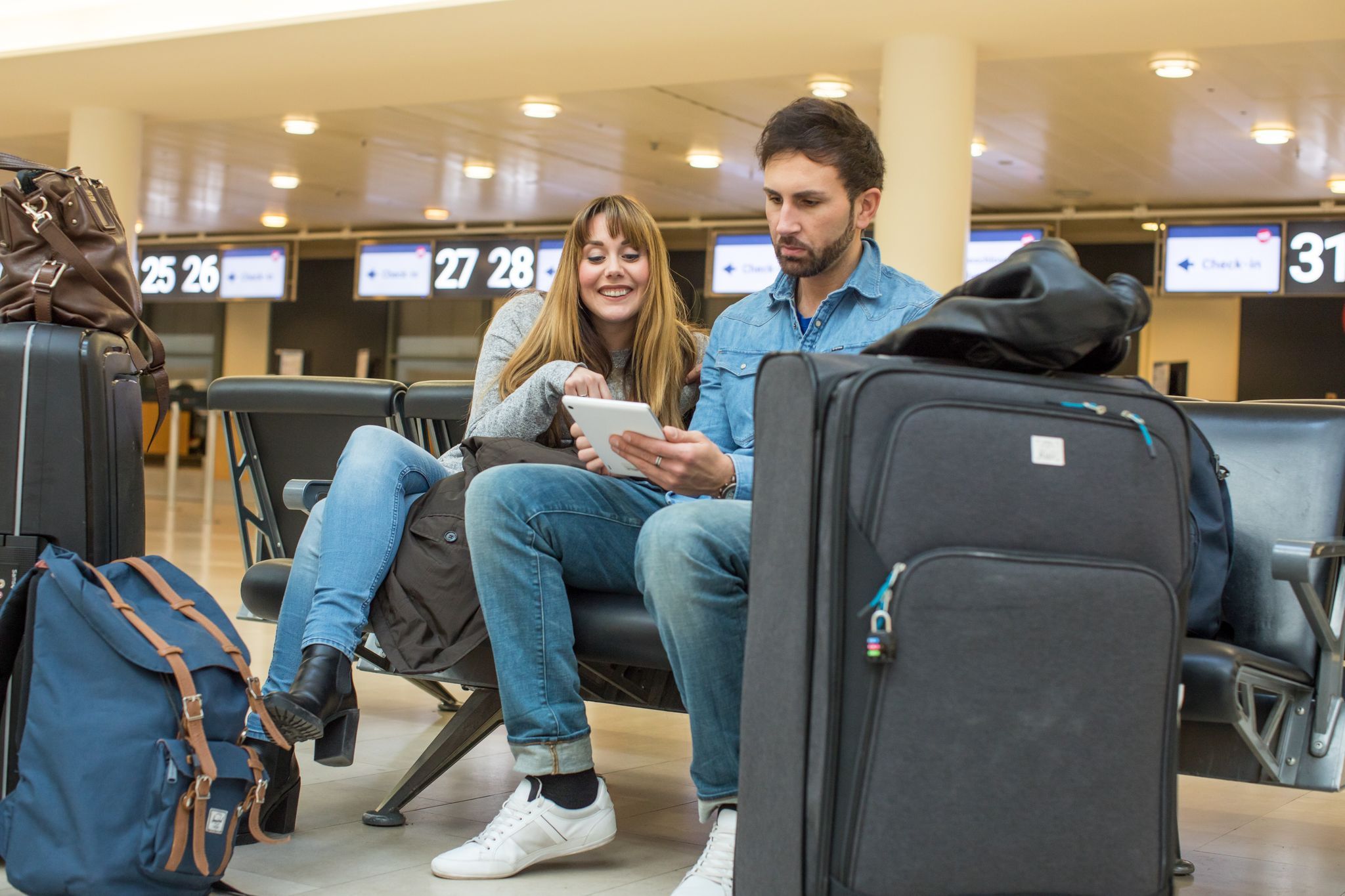 Ein Paar sitzt am Flughafen in der Check-In-Halle