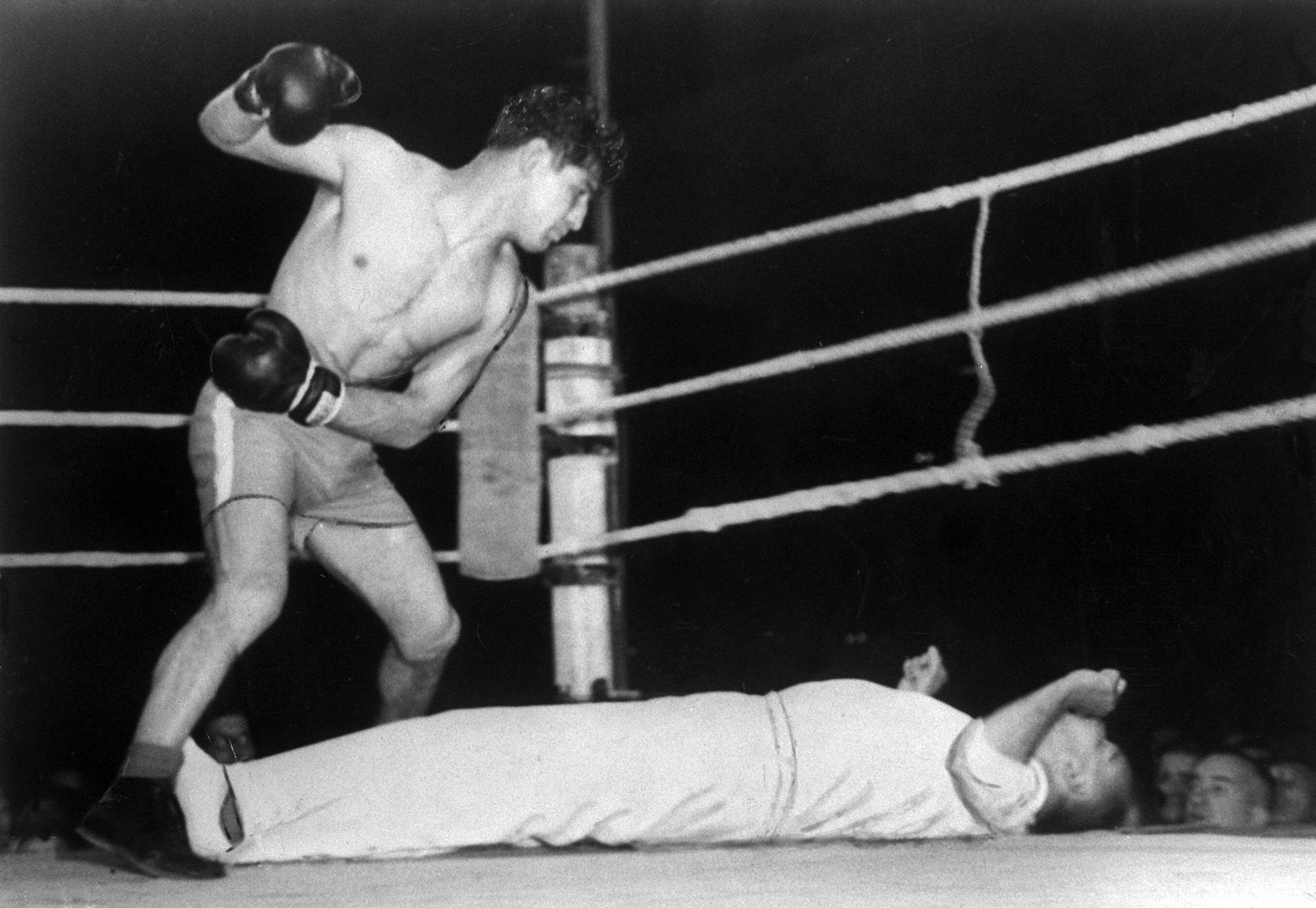 Der Kölner Boxer Peter Müller, genannt "de Aap" (= der Affe), schaut auf den Ringrichter Max Pippow, der K.o. auf dem Boden des Ringes liegt (1952).