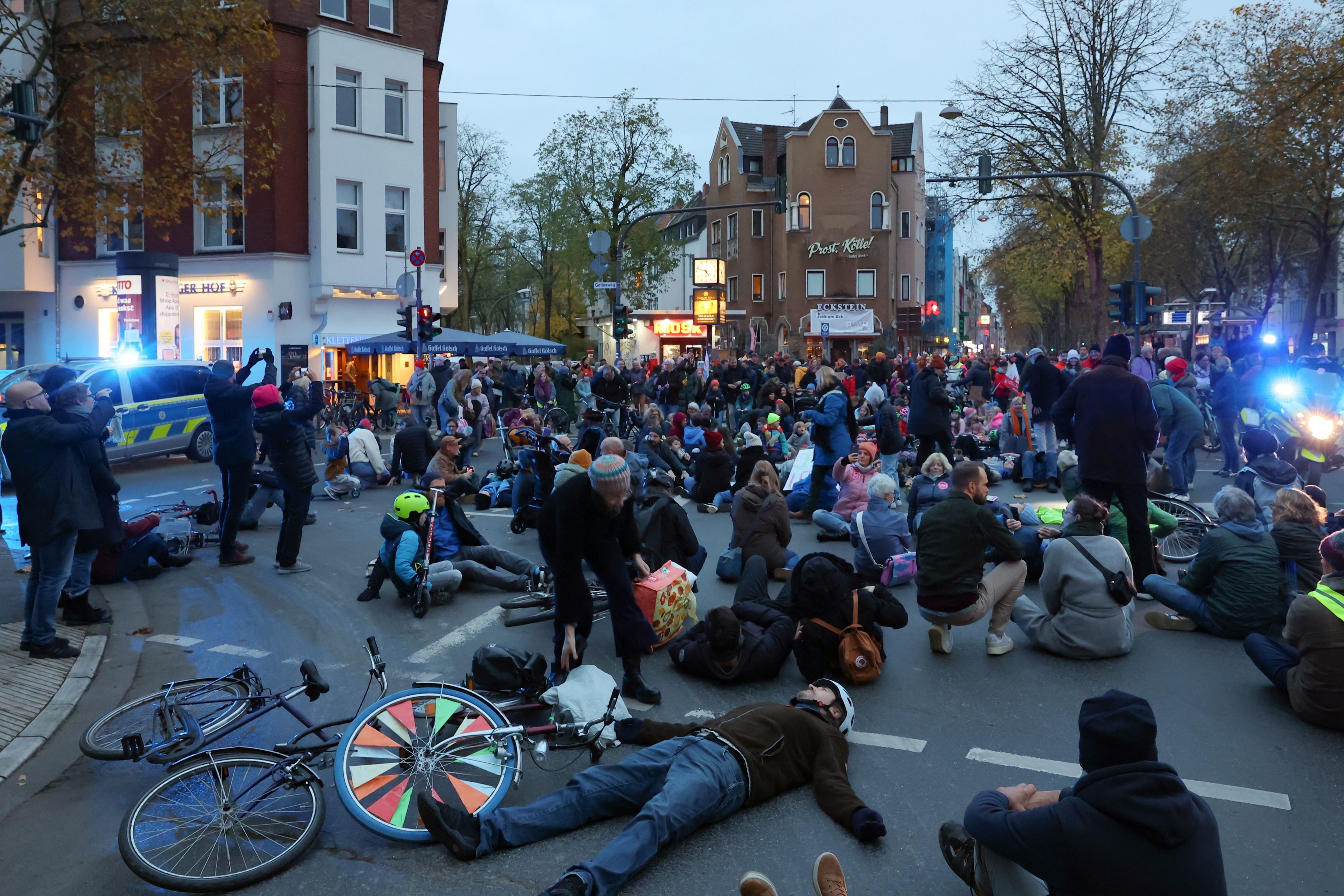 Demonstranten stehen und liegen auf einer Straßenkreuzung.