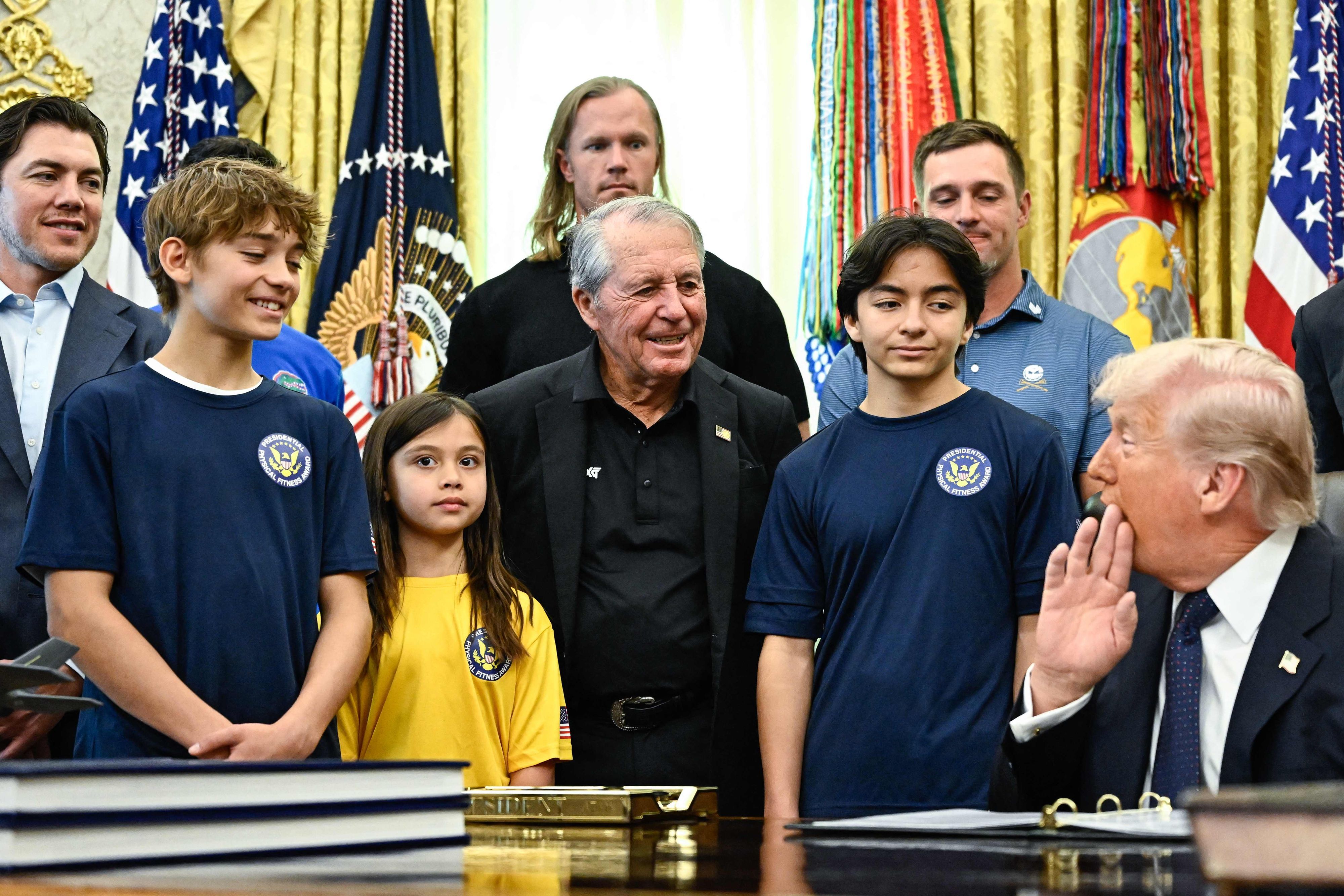 Donald Trump (r.) am Dienstag (5. Mai) im Weißen Haus mit der südafrikanischen Golf-Legende Gary Player (M.) und Schülerinnen und Schülern
