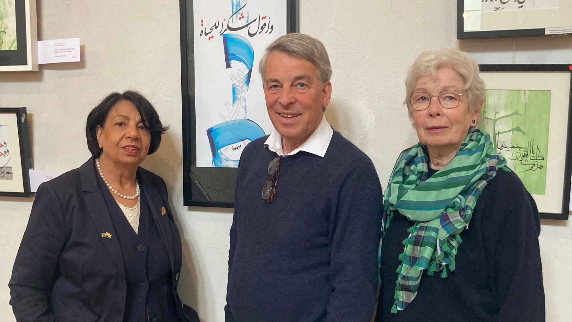 Suraya Hoffmann, Albrecht Schröter und Maria Meiwes vor Bildern der Kalligrafie-Ausstellung in St. Maternus.